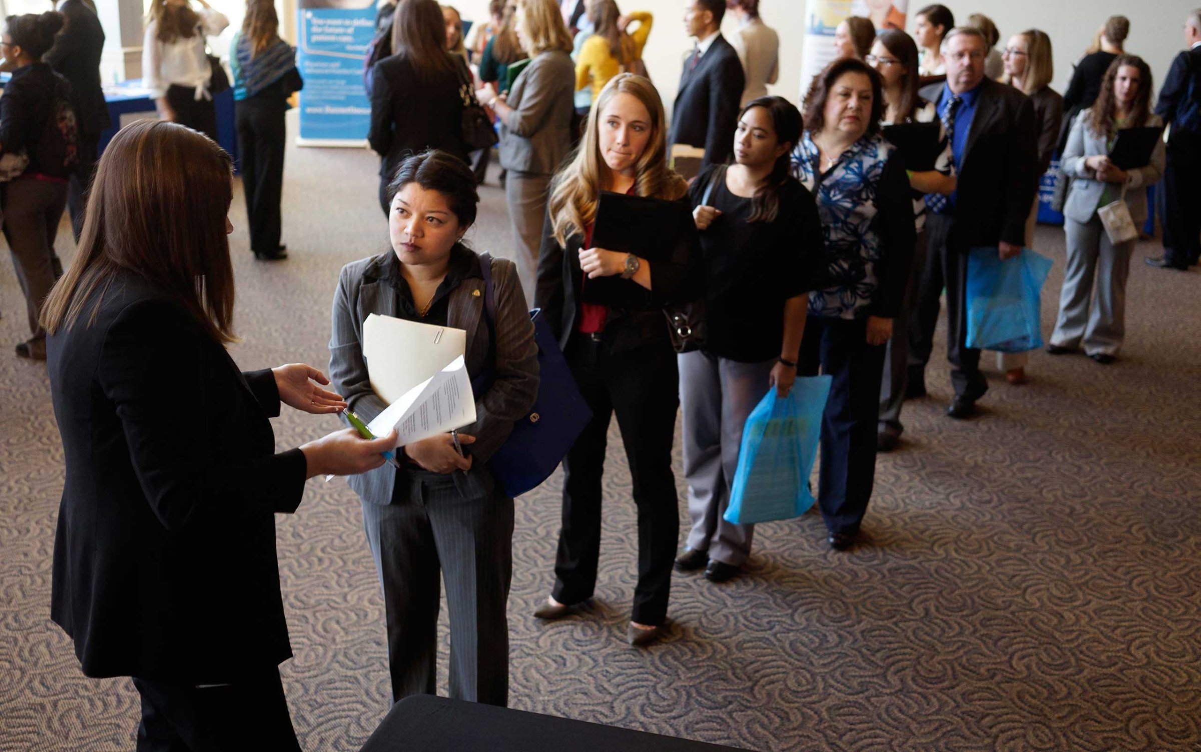 Jobseekers wait to talk to a recruiter at the Colorado Hospital Association's health care career event in Denver, Oct. 13, 2014.