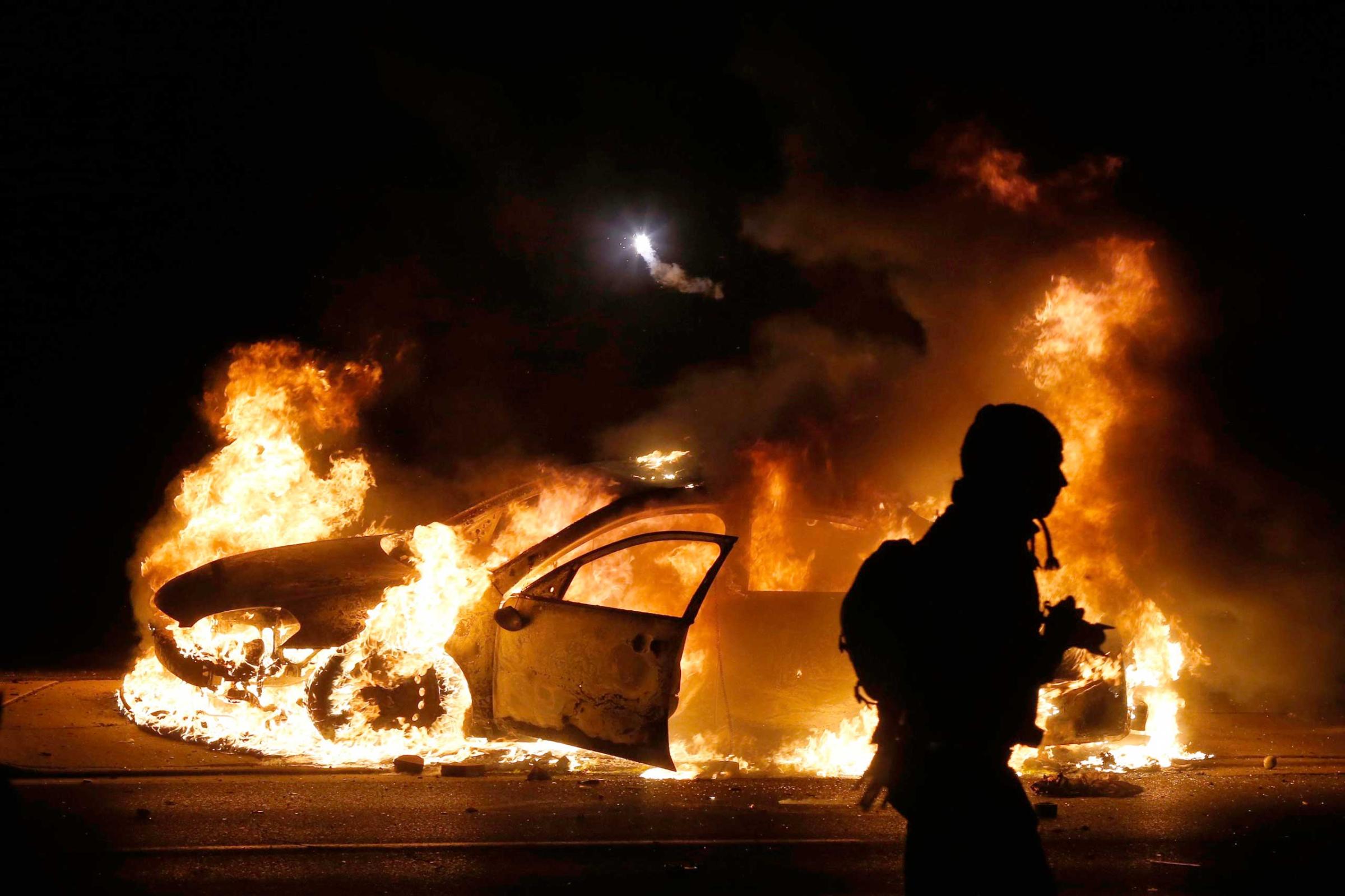 A police car burns on the street after a grand jury returned no indictment in the shooting of Michael Brown in Ferguson, Missouri