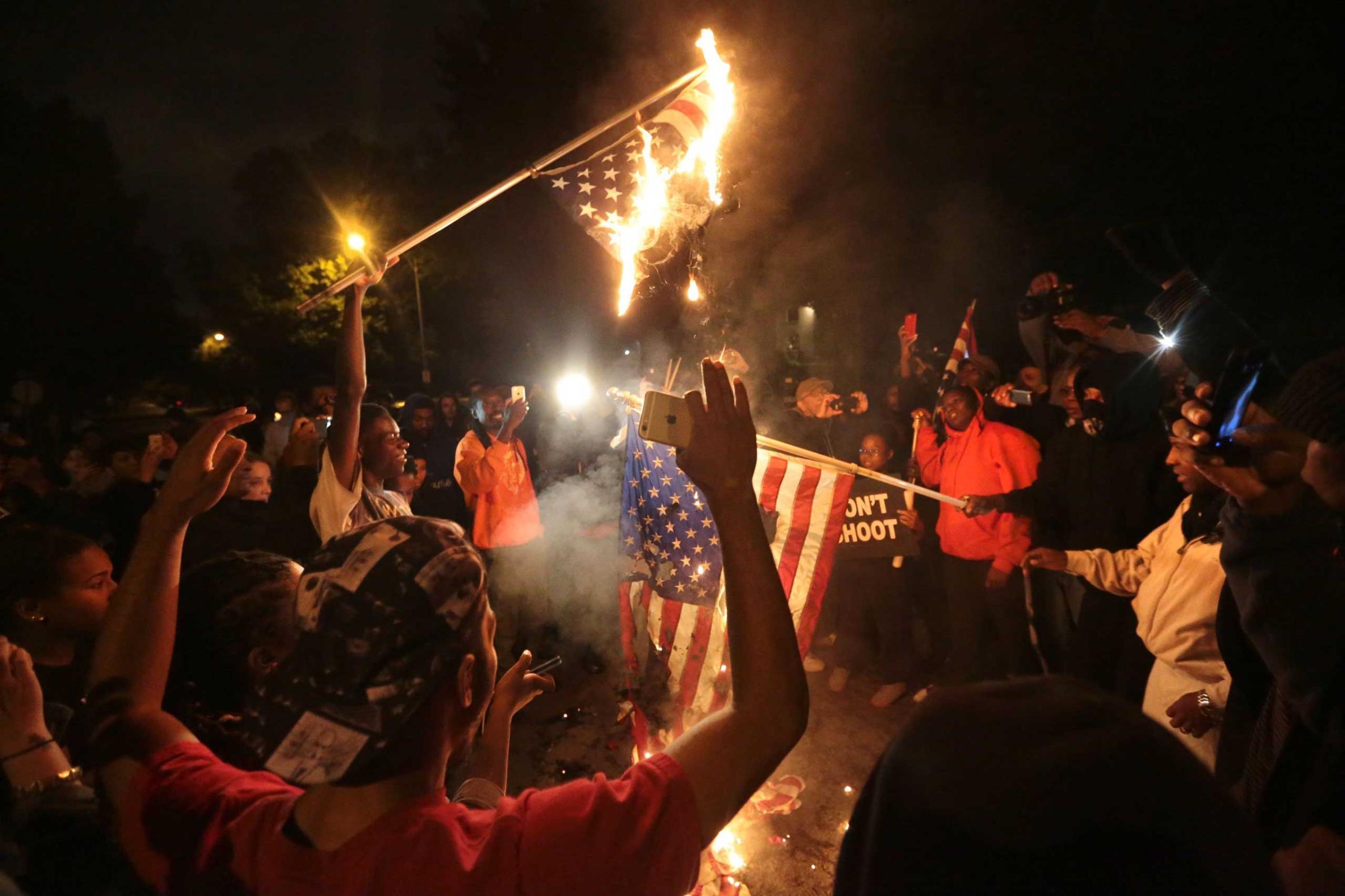 Several American flags are burned during a night of protest after a candlelight vigil for Vonderrit Myers, Jr. in St. Louis on Oct. 8, 2014.