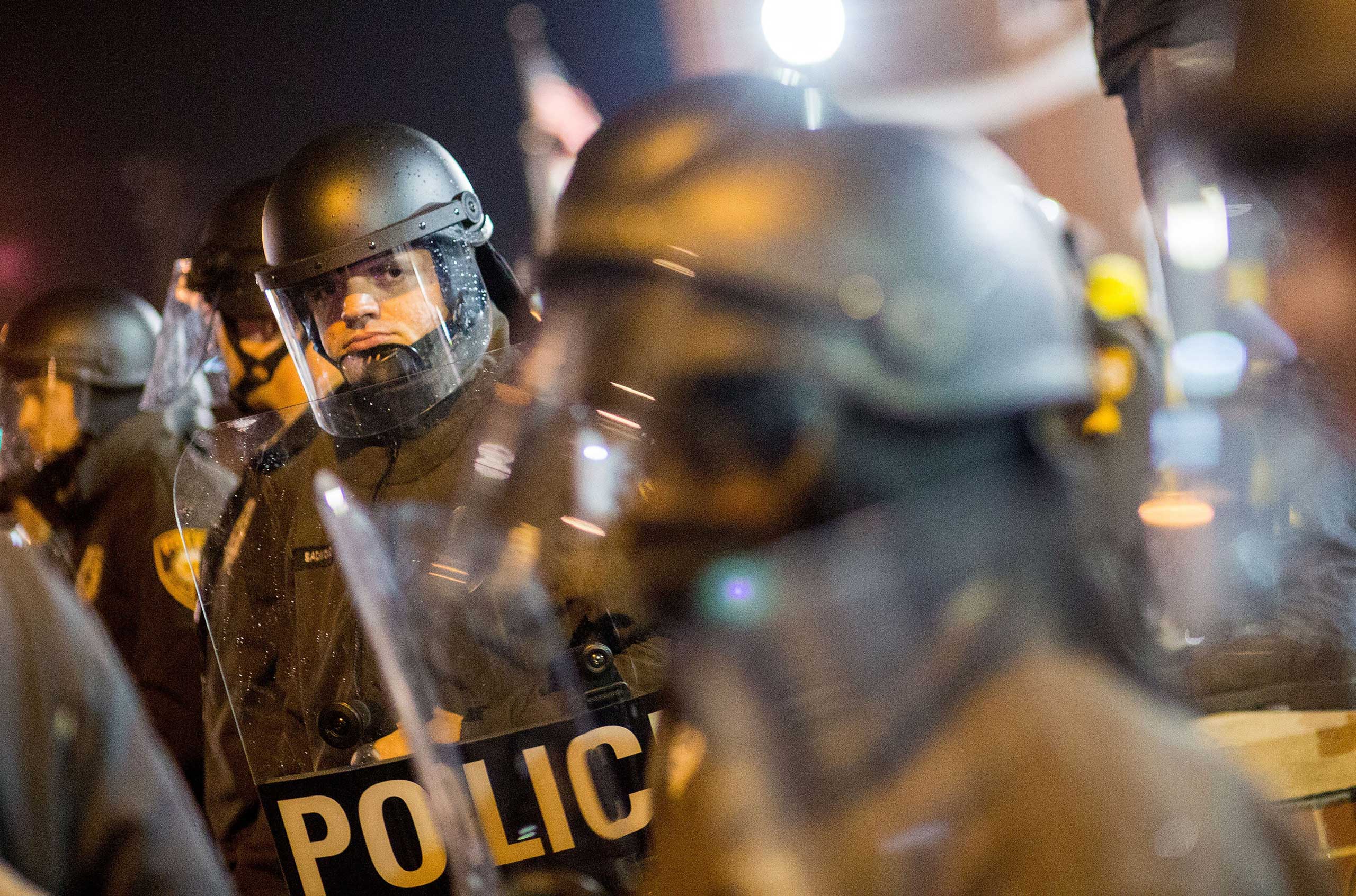 Police in riot gear observe protesters on the street near the Ferguson Police Station in Ferguson, Mo. on Nov. 23, 2014 (Shen Ting—Xinhua Press/Corbis)