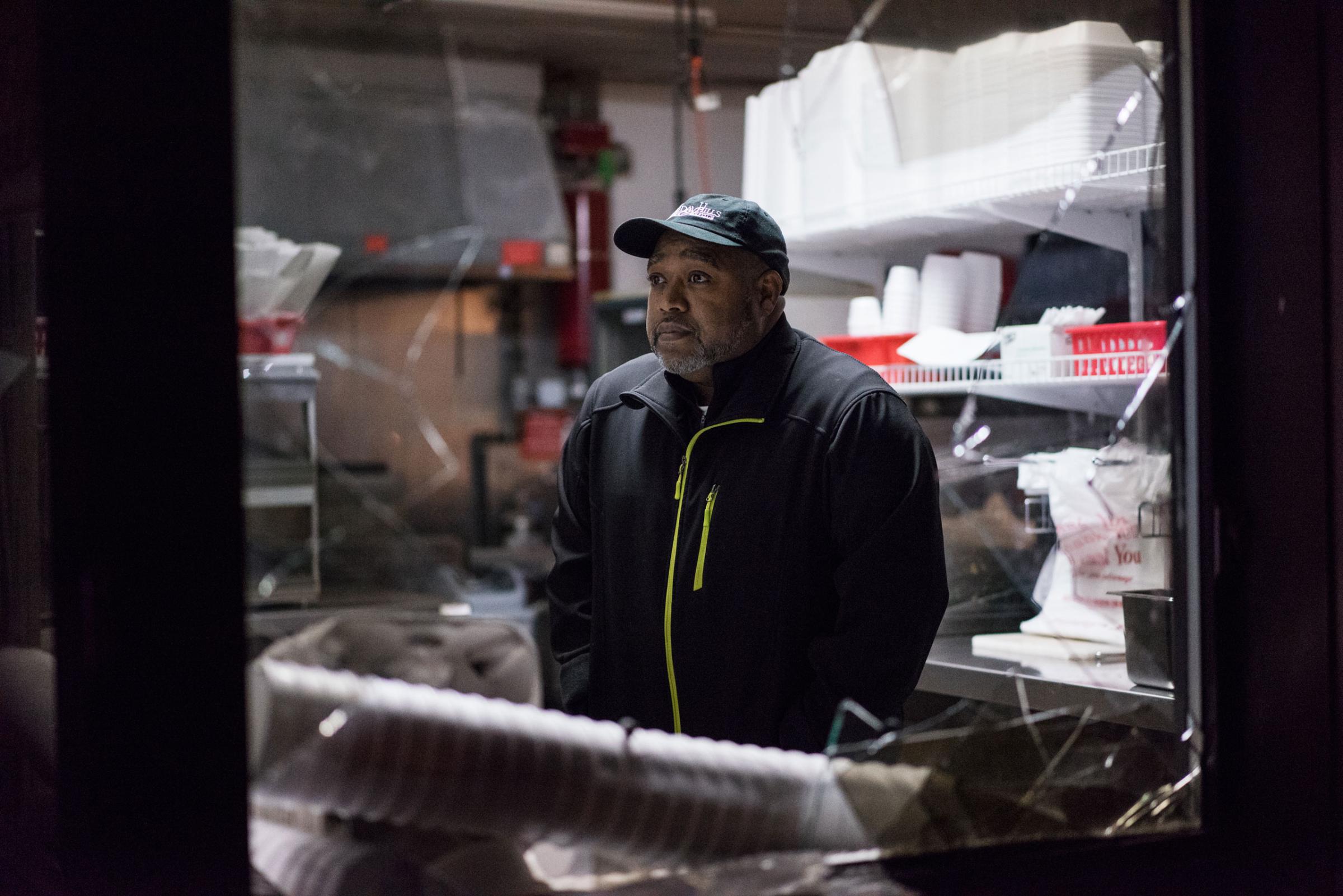 Patrick London surveys the damage at his fast food restaurant London's Wing House after it was looted during protests on November 24, 2014.