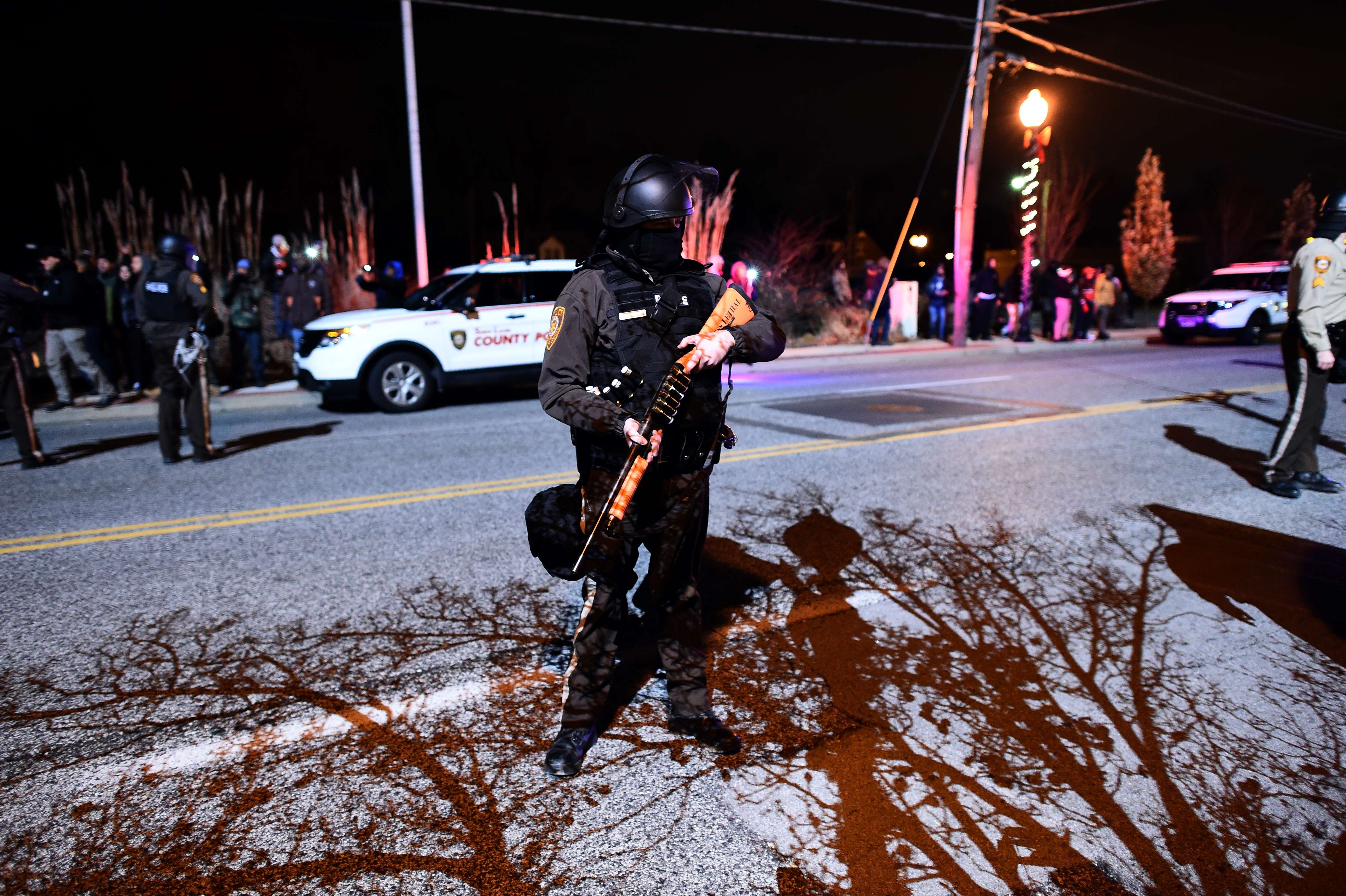 A police officer holds her gun during clashes with protesters in Ferguson, Mo. on Nov. 24, 2014.