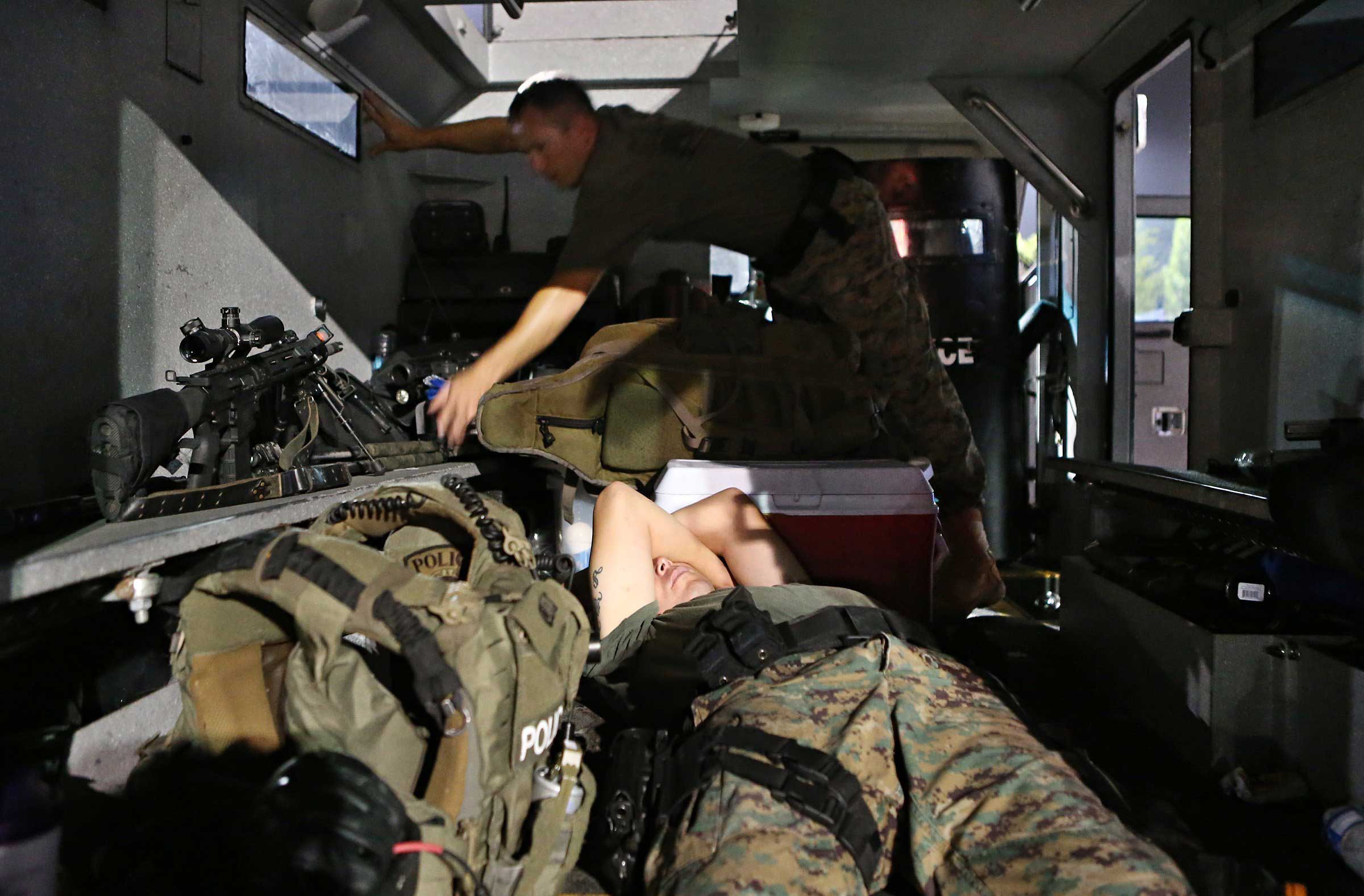 Aug. 19, 2014. A member of the St. Louis County Police tactical team sleeps in the back of the team's armored truck after arriving back at the command post W. Florissant Avenue at about 2.49 a.m.