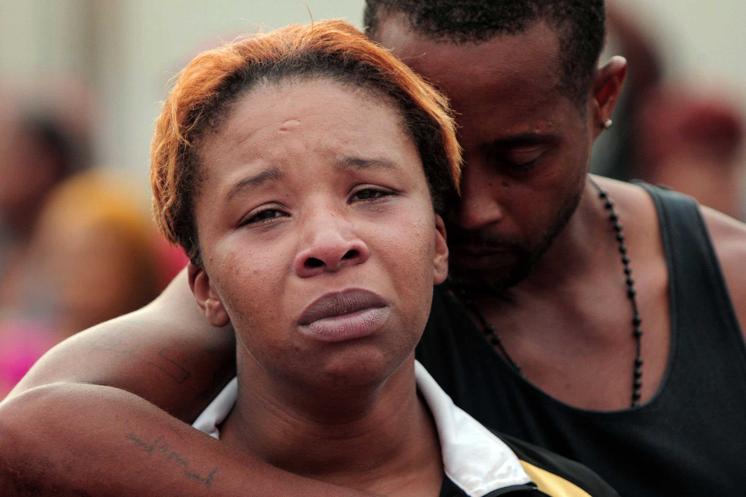 Aug. 9, 2014. Lesley McSpadden, left, is comforted by her husband, Louis Head, after her 18-year-old son, Michael Brown was shot and killed by police in the middle of the street in Ferguson, Mo., near St. Louis on Saturday. A spokesman with the St. Louis County Police Department, which is investigating the shooting at the request of the local department, confirmed a Ferguson police officer shot the man. The spokesman didn't give the reason for the shooting.