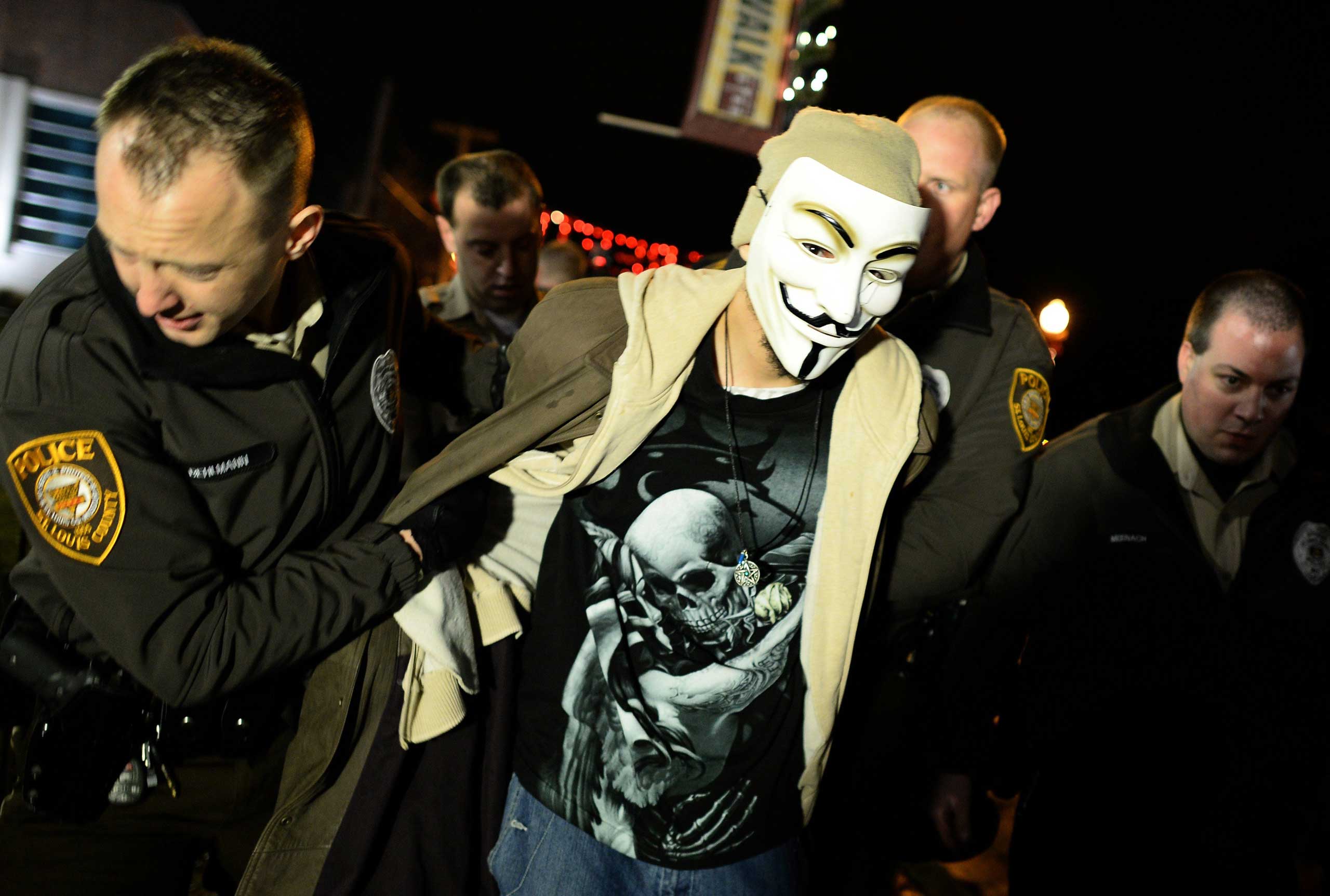 Police detain a demonstrator after he and others blocked a street near a police station in Ferguson, Mo. on Nov. 23, 2014