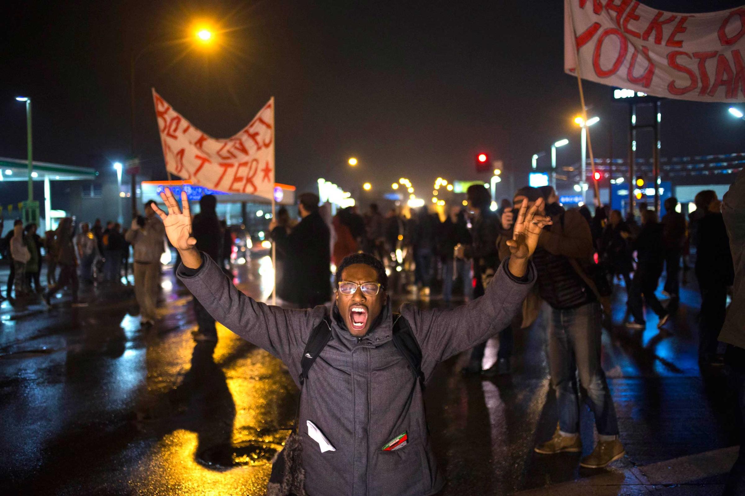 A protester, demanding the criminal indictment of a white police officer who shot dead an unarmed black teenager in August, shouts slogans while stopping traffic while marching through a suburb in St. Louis, Missouri