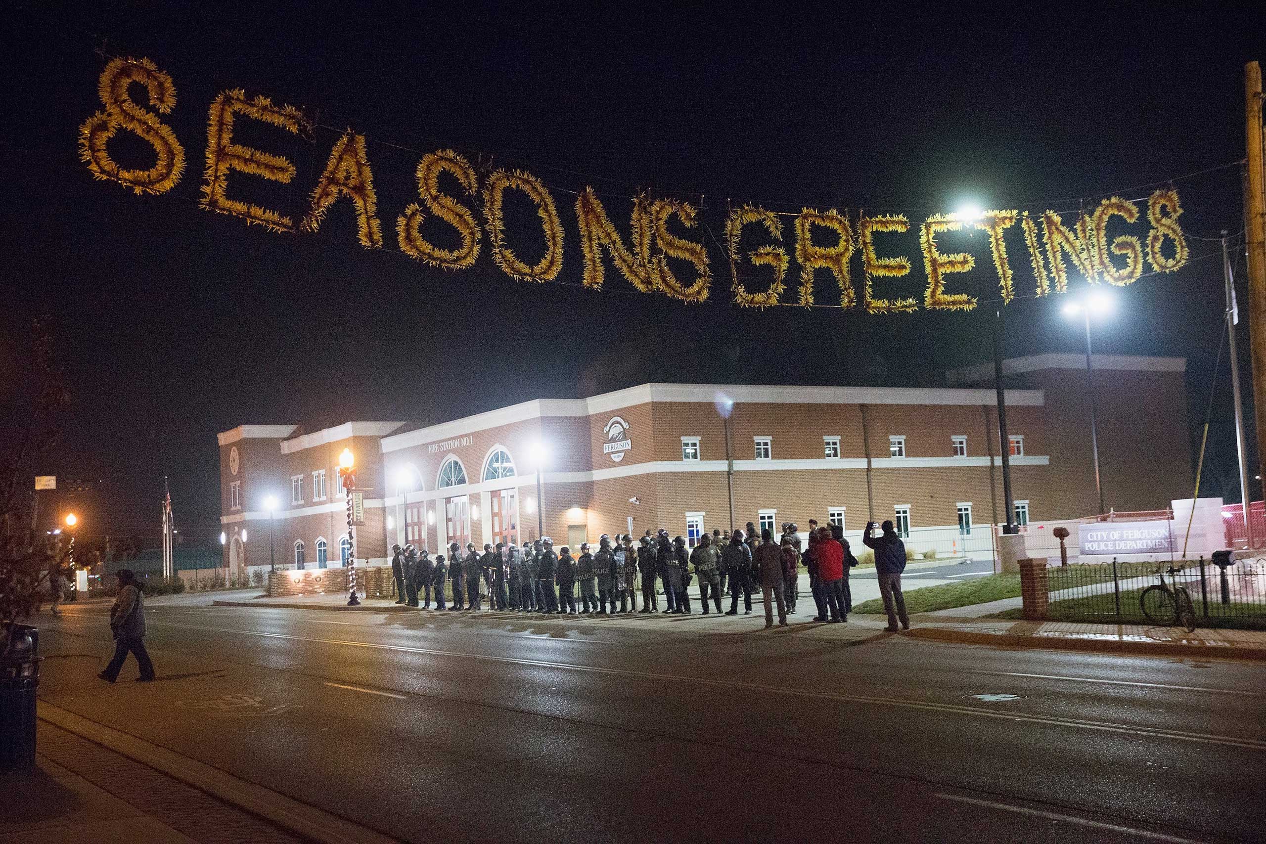 Police guard the Ferguson police station as demonstrators protest the shooting death of Michael Brown in Ferguson, Mo. on Nov. 20, 2014