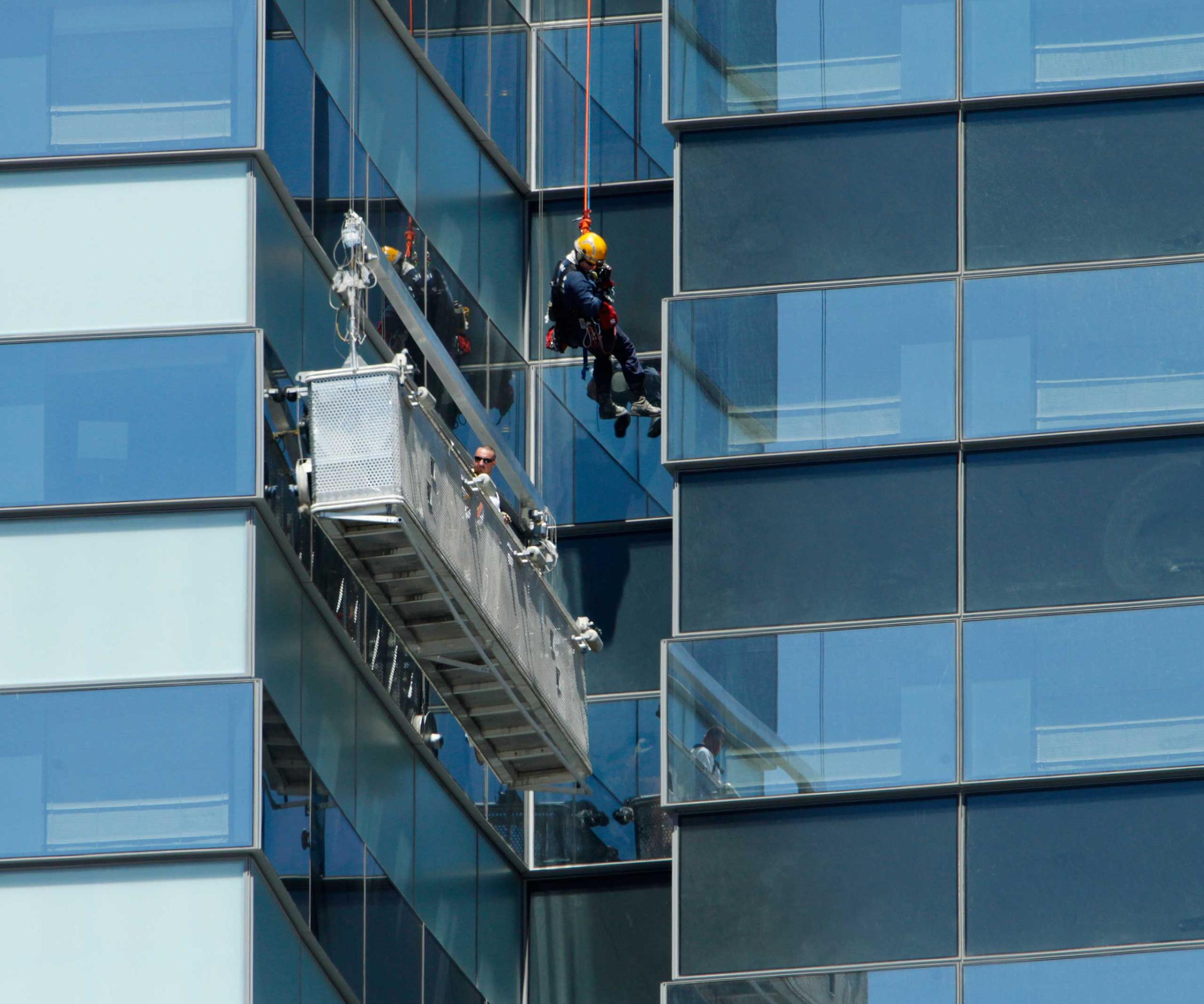 A Las Vegas Fire Department high-angle rescue worker lowers down to window washers who are stranded outside the 35th floor of the Vdara Hotel at CityCenter in Las Vegas on July 25, 2012.