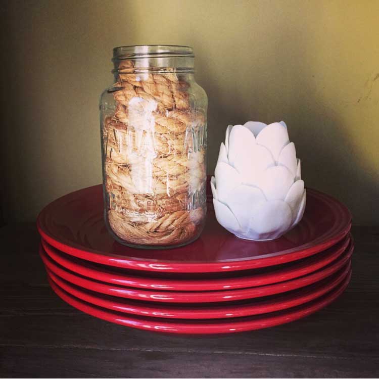 How did I miss this?! A rope in a jar! That's part of a decor service you pay people for!: A rope stuffed into a Mason jar! Why not place your "jar of rope" on a stack of plates next to a ceramic white artichoke candle? Stick it on a shelf in your dining room.