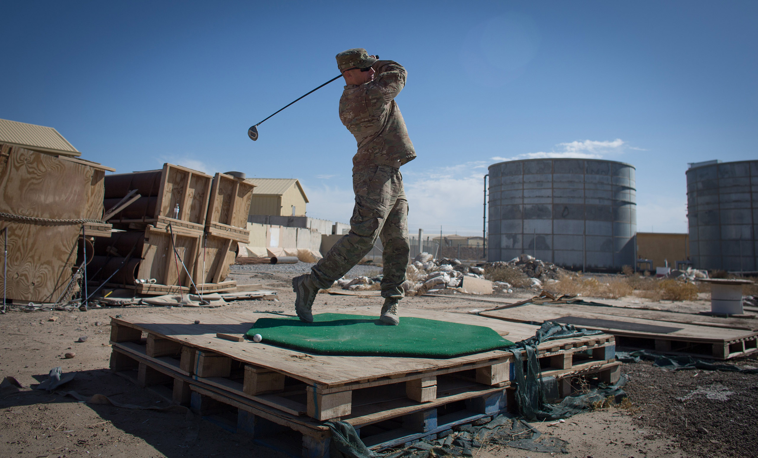 First sergeant Tony Quismundo from the US Army practices his golf on waste ground at Kandahar airfield on Nov. 10, 2014 in Kandahar, Afghanistan.