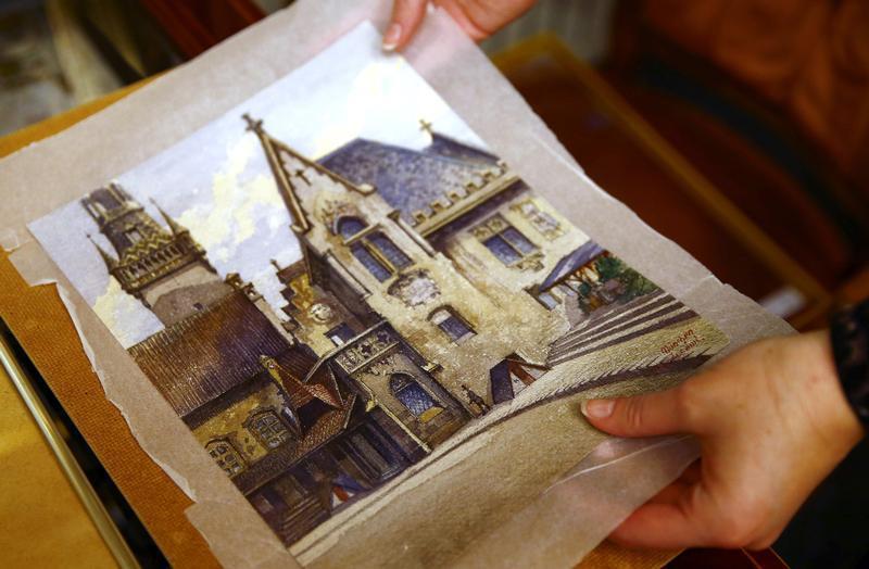 An employee puts away a watercolour of the old registry office in Munich by former German dictator Adolf Hitler at Weidler auction house in Nuremberg November 18, 2014. (Kai Pfaffenbach—Reuters)