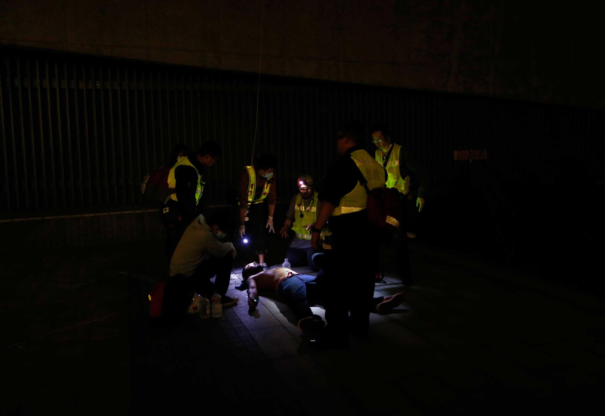 A pro-democracy protester is examined by rescue volunteers after being pepper sprayed by the police as he and others tried to break into the Legislative Council in Hong Kong early Nov. 19, 2014, in response to an earlier clear up by bailiffs on part of the "Occupy Central" protest site.