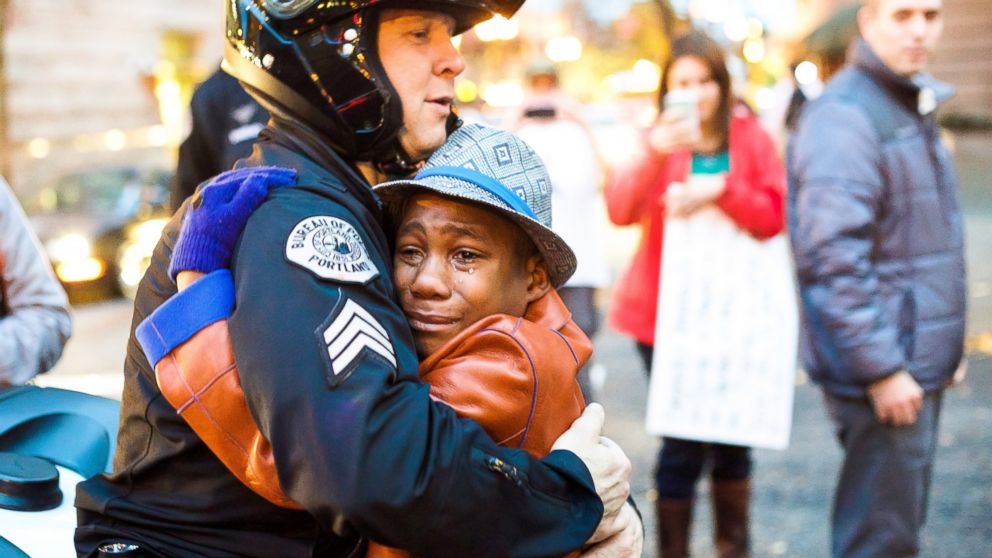 Police Sgt. Bret Barnum hugs 12-year-old Devonte Hart during a demonstration in Portland, Ore., Nov. 25, 2014. (Johnny H. Nguyen)