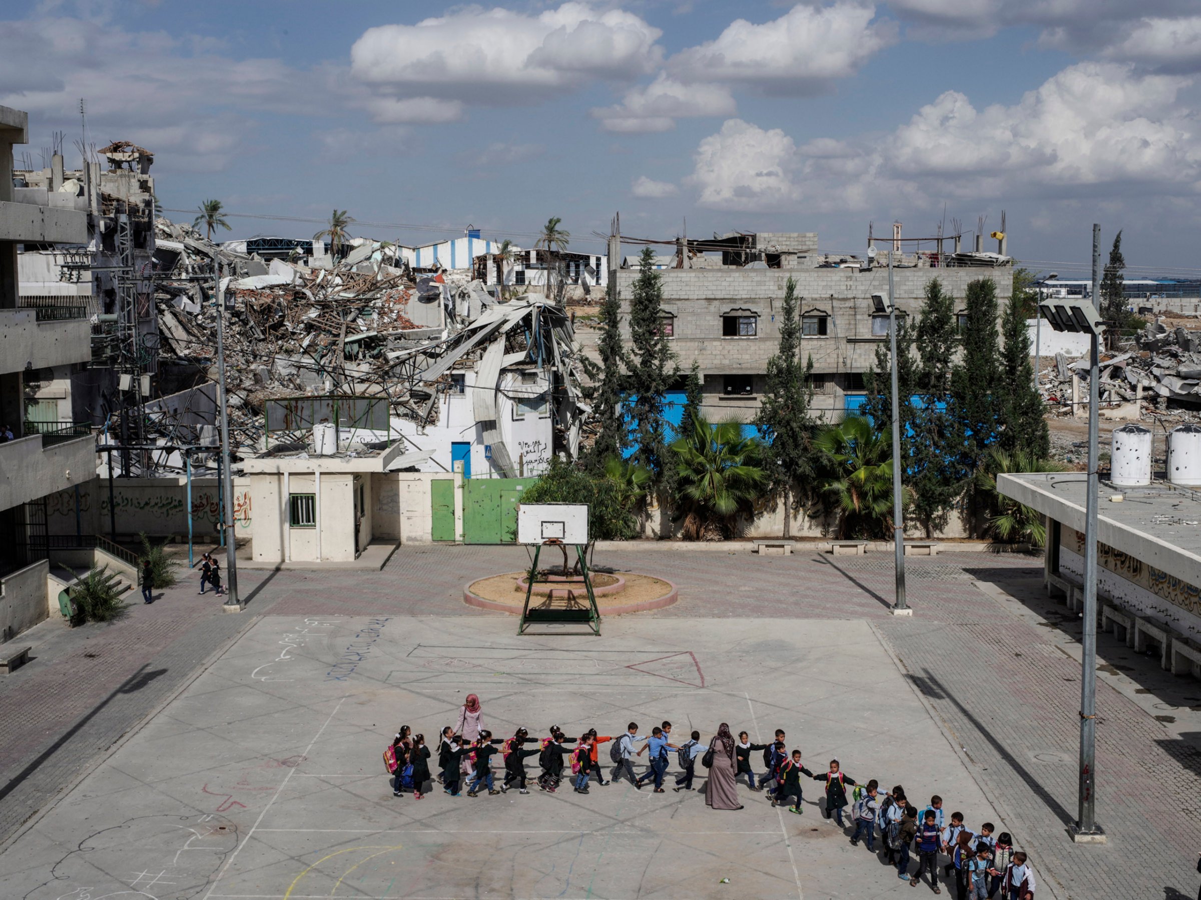 2014.  Gaza.  Palestine.  Schoolchildren head to class at the Sobhi Abu Karsh School in the Shujai'iya neighborhood. Operation Protective Edge lasted from 8 July 2014 – 26 August 2014, killing 2,189 Palestinians of which 1,486 are believed to be civilians. 66 Israeli soldiers and 6 civilians were killed.  It's estimated that 4,564 rockets were fired at Israel by Palestinian militants.