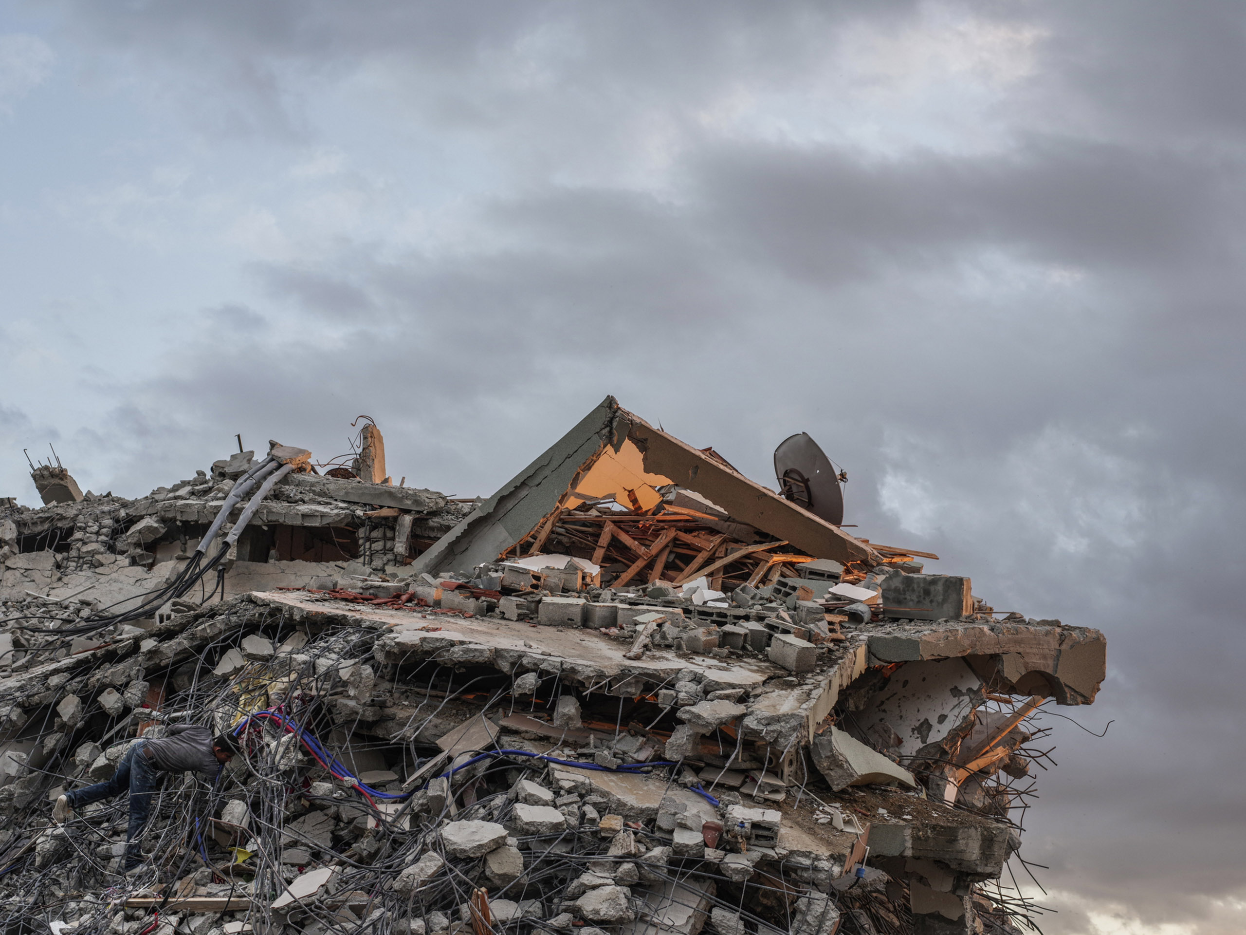 A man salvages scrap from a destroyed building in the Shujai'iya neighborhood, Gaza.