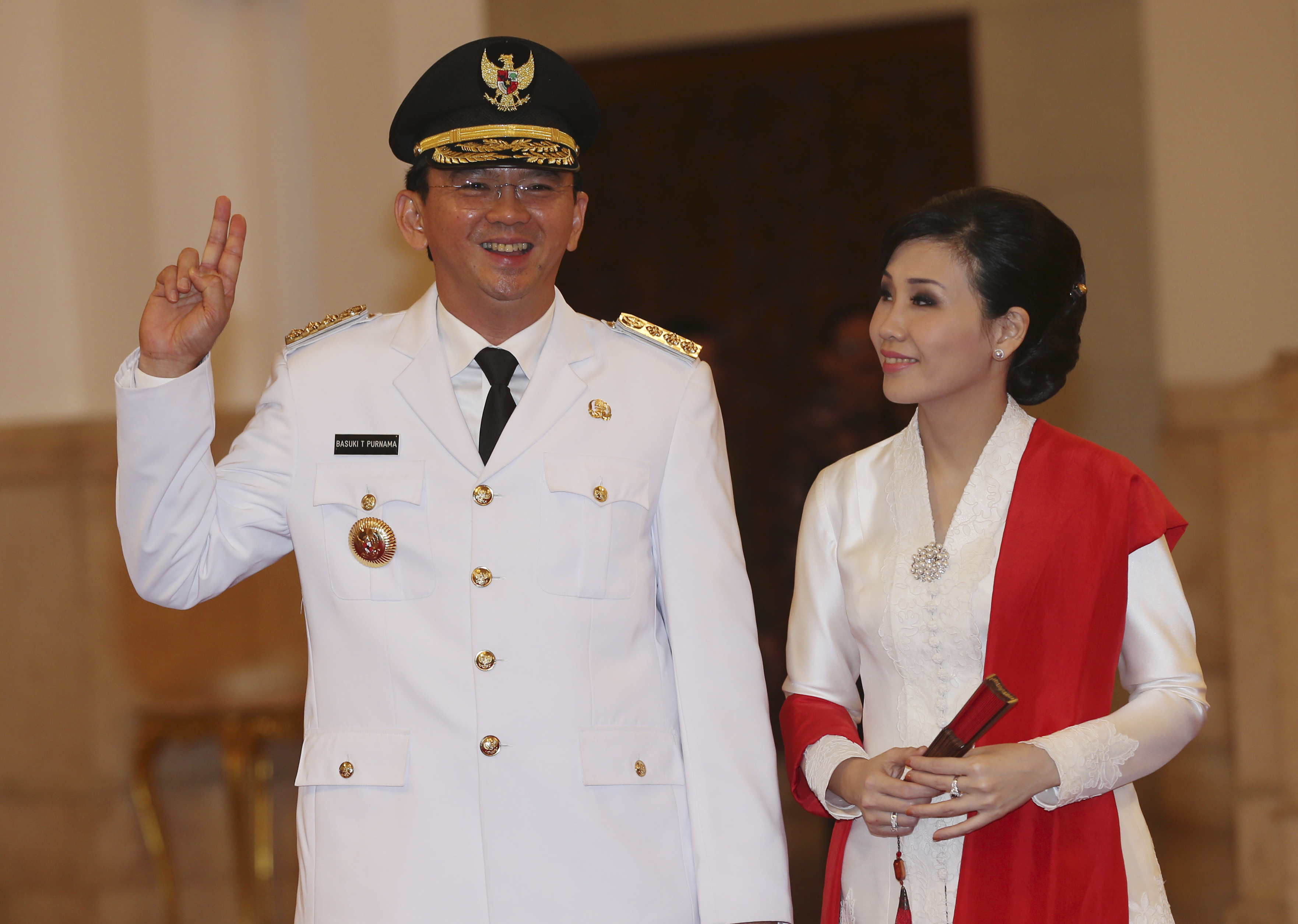 Basuki Tjahaja Purnama, with his wife Veronica Tan, poses prior to taking the oath of office to become the governor of Indonesia's capital Jakarta on Nov. 19, 2014 (Tatan Syuflana—AP)