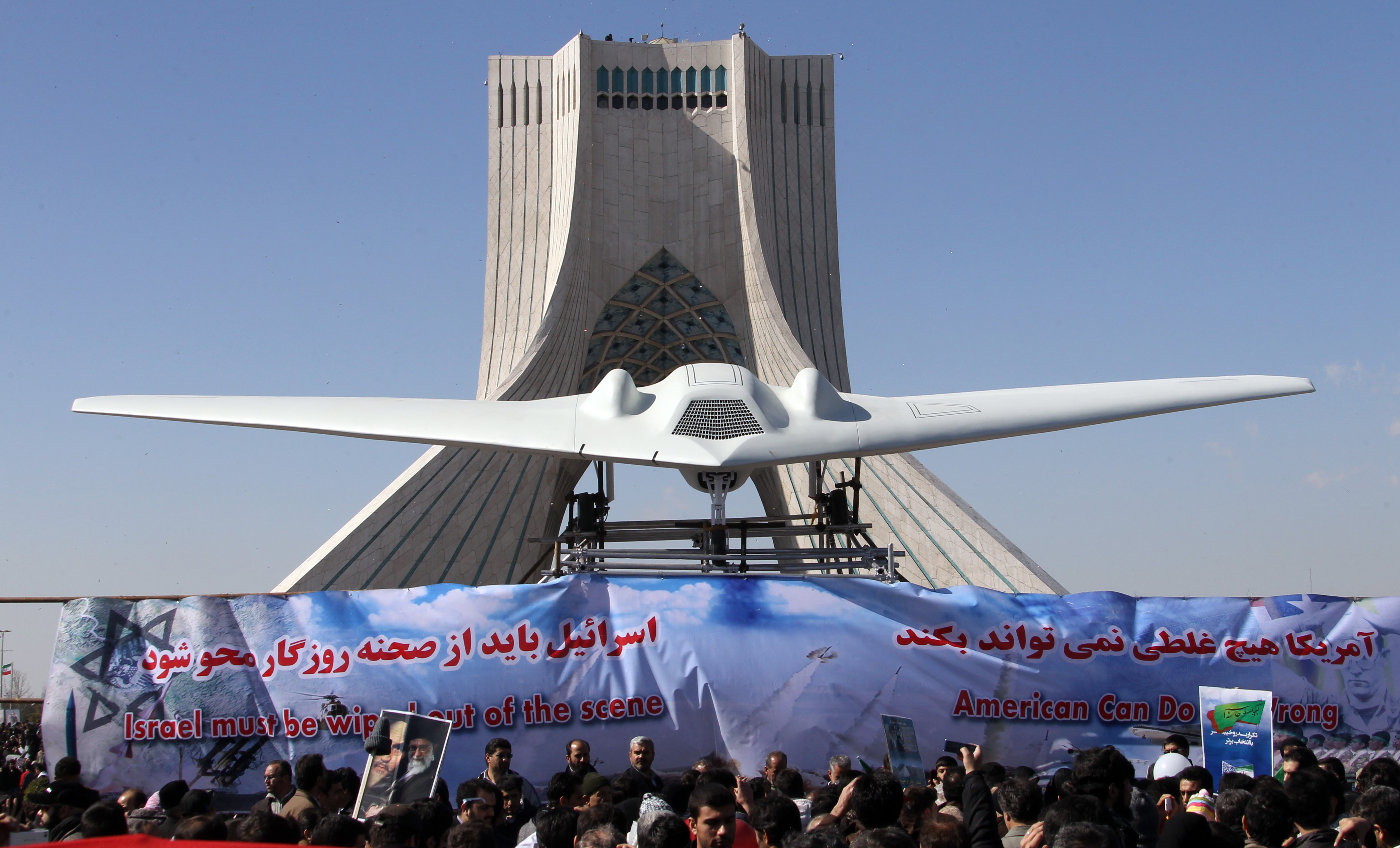 Iranians walk past a replica of the captured US RQ-170 drone which is on display next to the Azadi (Freedom) tower during the 33rd anniversary of the Islamic revolution in Tehran on February 11, 2012. (Atta Kenare&mdash;AFP/Getty Images)