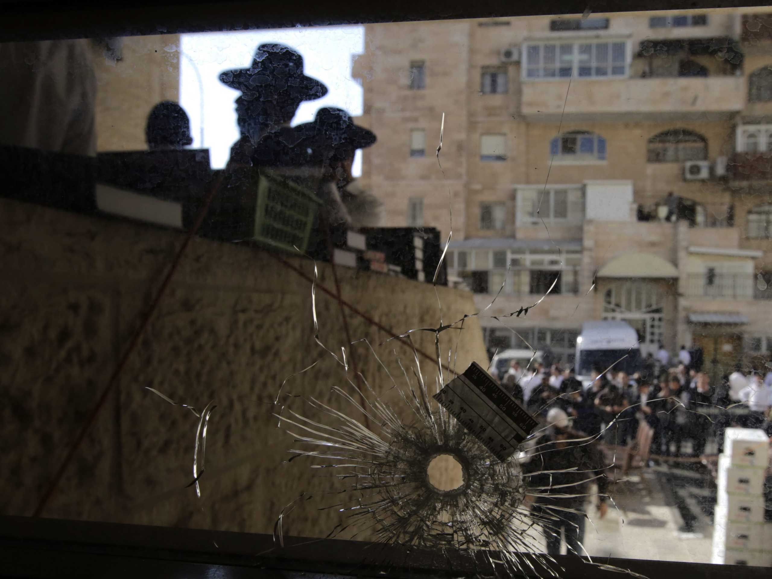 A bullet hole through the front window of a synagogue in the Har Nof neighborhood of Jerusalem on Nov. 18, 2014.