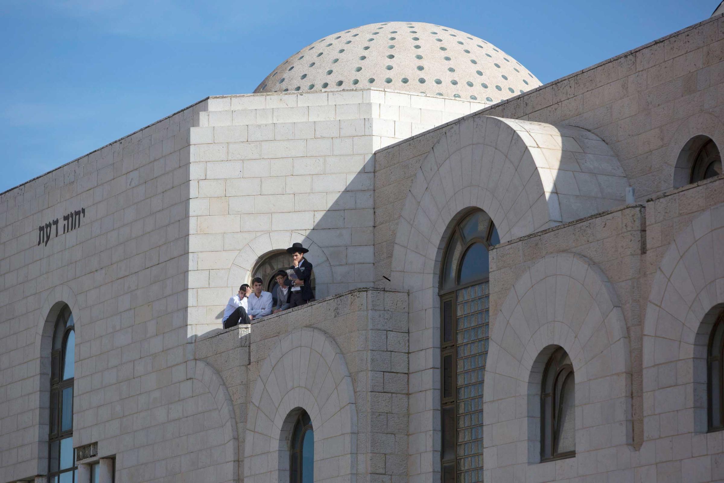 Ultra-Orthodox Jewish youths look at the scene of a shooting attack in a synagogue in Jerusalem, Nov. 18, 2014.