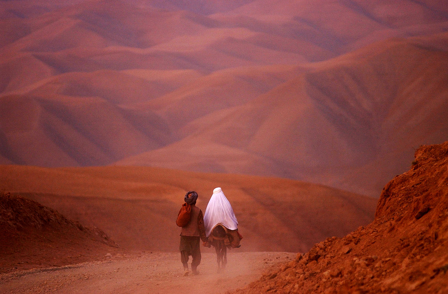 A MAN AND WOMAN WENT THROUGH THE BARREN MOUNTAINS OF BADAKHSHAN PROVNCE IN NORTHERN AFGHANISTAN, ONE OF THOSE MOST DEEPLY AFFECTED BY THE RECENT DROUGHT, ON THEIR WAY TO THE TOWN OF KEMISH IN THE AREA CONTROLLED BY THE NORTHERN ALLIANCE.  PHOTO BY JAMES HILL/19 OCTOBER 2001.