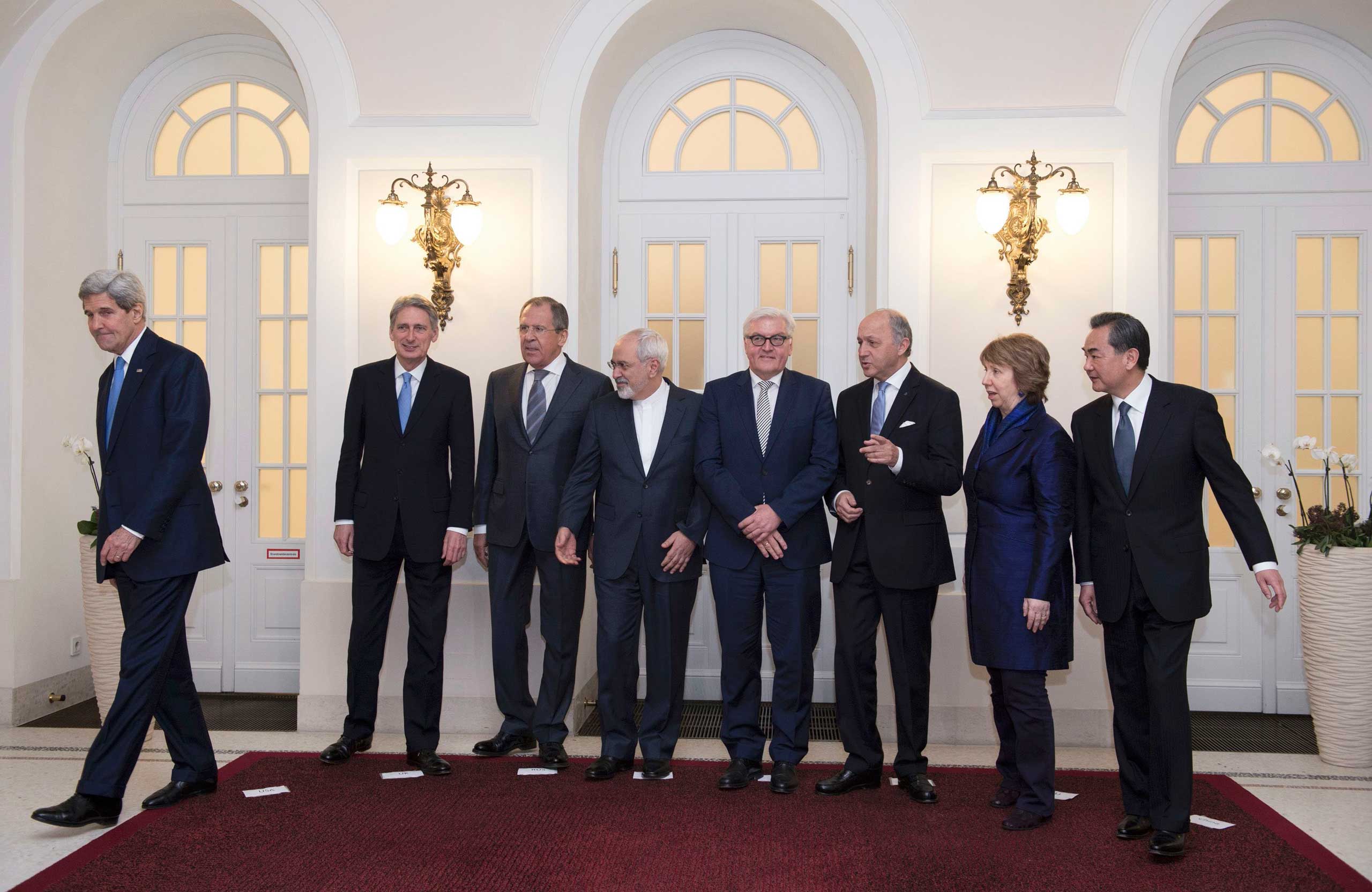 U.S. Secretary of State Kerry steps out as Britain's Foreign Secretary Hammond, Russian Foreign Minister Lavrov, Iranian FM Zarif and German FM Steinmeier, French FM Fabius, EU envoy Ashton and Chinese FM Yi pose in Vienna