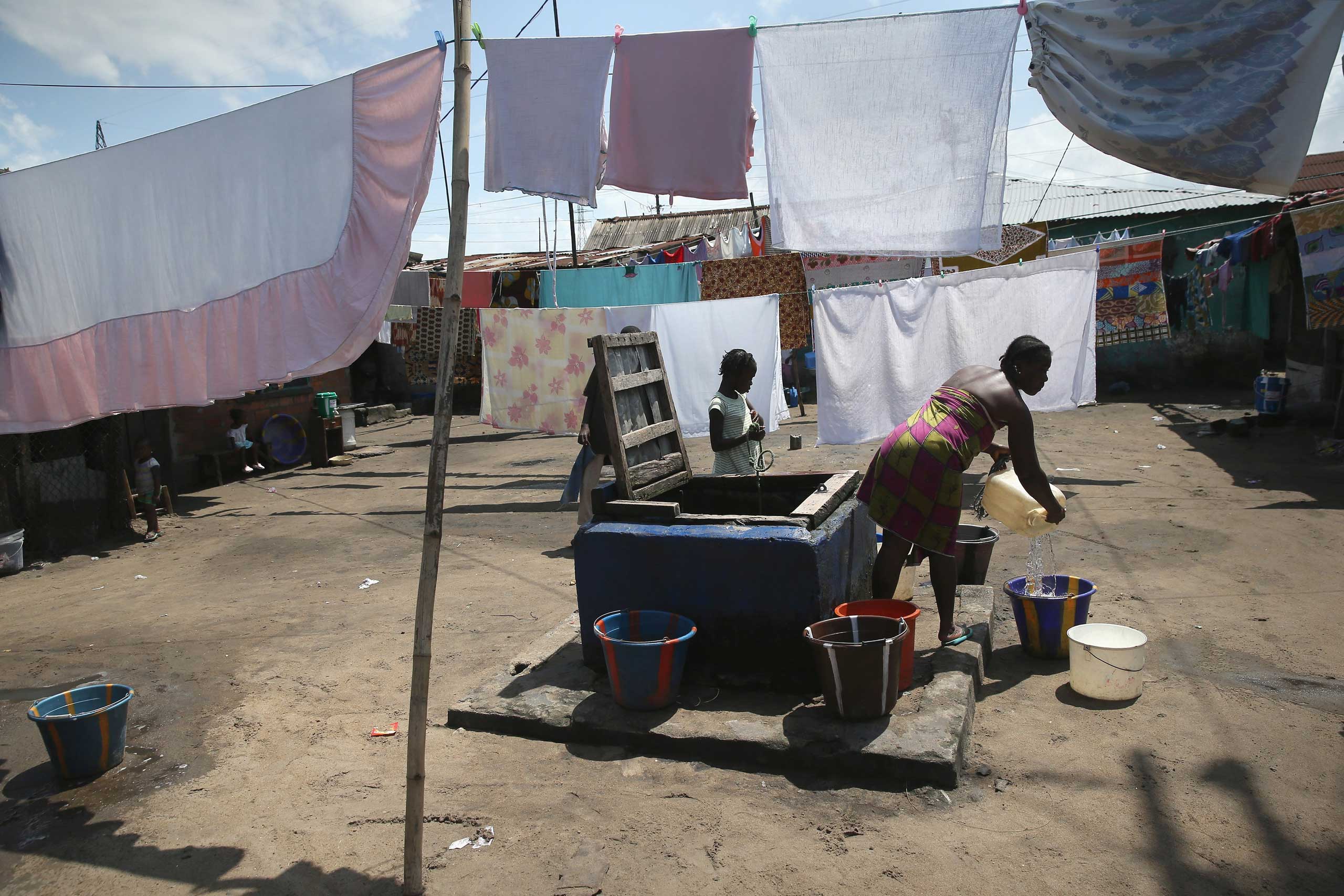 People draw water in the West Point neighborhood, where many people have died from Ebola, in Monrovia, Liberia on Oct. 17, 2014. (John Moore—Getty Images)