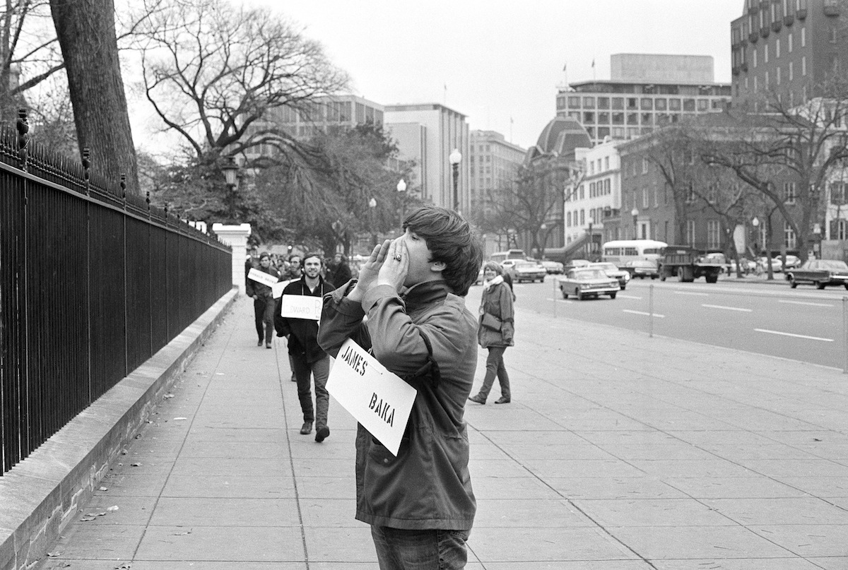 Wearing the name of a serviceman who died in Vietnam, a marcher pauses in front of the White House on Nov. 14, 1969 (AP Images)