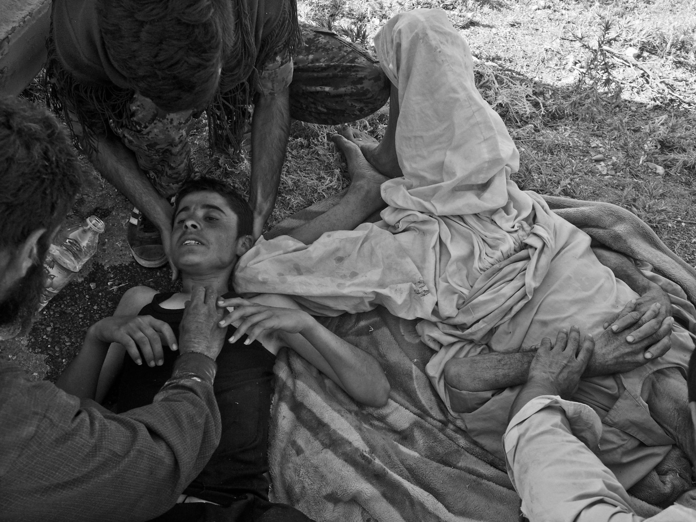 Wounded Yezidi refugees receive care after a helicopter crash. Sinjar Mountains, Iraq. Aug. 12, 2014.