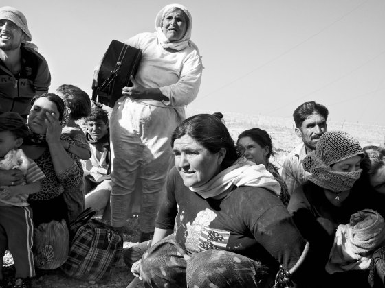 Stranded Yezidi families huddle together as they await to board a rescue helicopter. Sinjar Mountains, Iraq. Aug. 12, 2014.