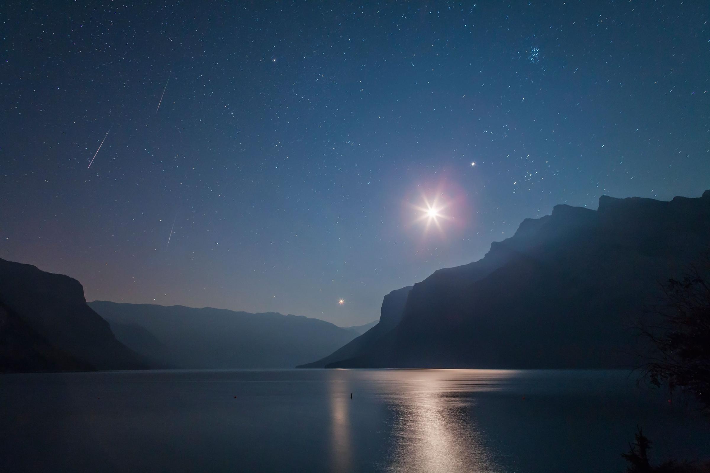 Three Perseid meteors appear in the predawn sky over Lake Minnewanka in Banff National Park, Alberta, Canada on Aug. 12, 2012.