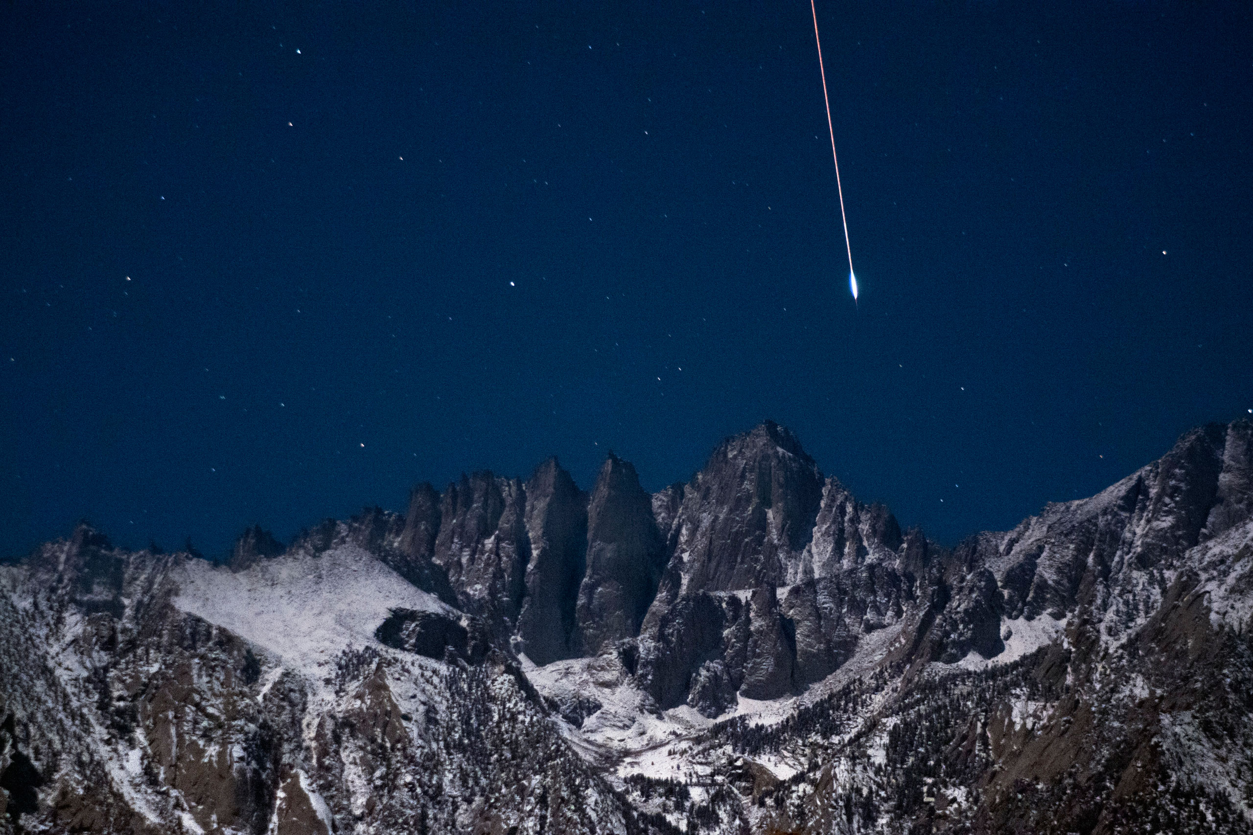A bright Geminid meteor falls from the sky over the summit of 14,505 foot Mount Whitney in California's Sierra Nevada mountains on Dec. 14, 2011.