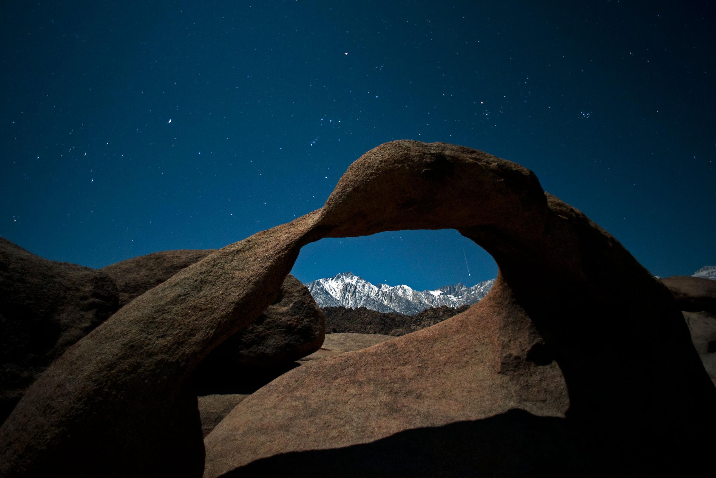 Framed within Mobuis Arch, a Geminid meteor streaks through a starfilled sky above the Sierra Nevada mountains in California's Eastern Sierra on Dec. 14, 2011.