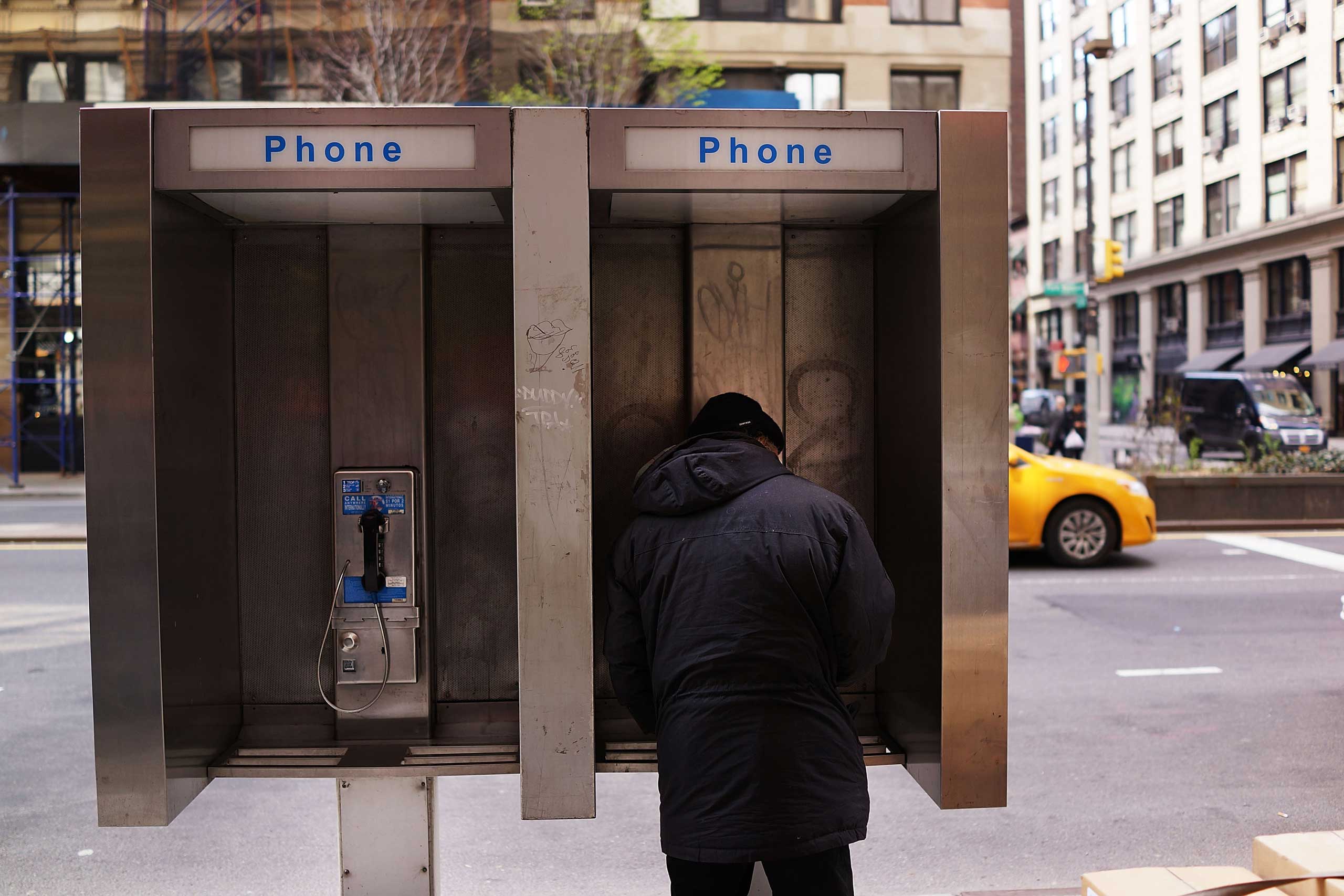 A man stands in a public phone booth on a Manhattan street on May 2, 2014 in New York City. (Spencer Platt—Getty Images)