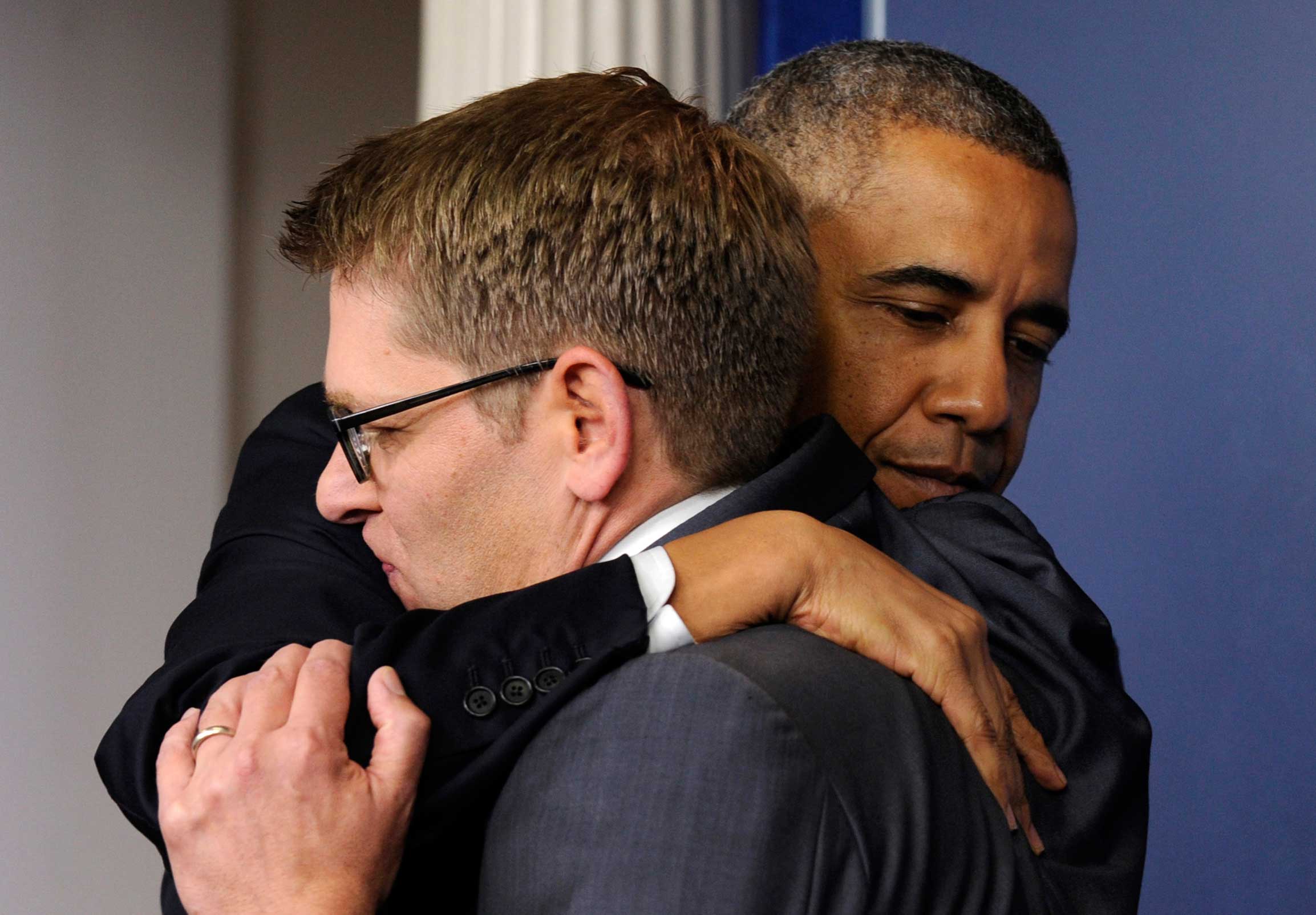 President Barack Obama gives White House press secretary Jay Carney a hug after announcing that Carney will step down later next month, during a surprise visit to the Brady Press Briefing Room of the White House, Friday, May 30, 2014. The president announced Carney's departure in a surprise appearance at in the White House press briefing room Friday. He said principal deputy press secretary Josh Earnest will take over the job. (AP Photo/Susan Walsh)