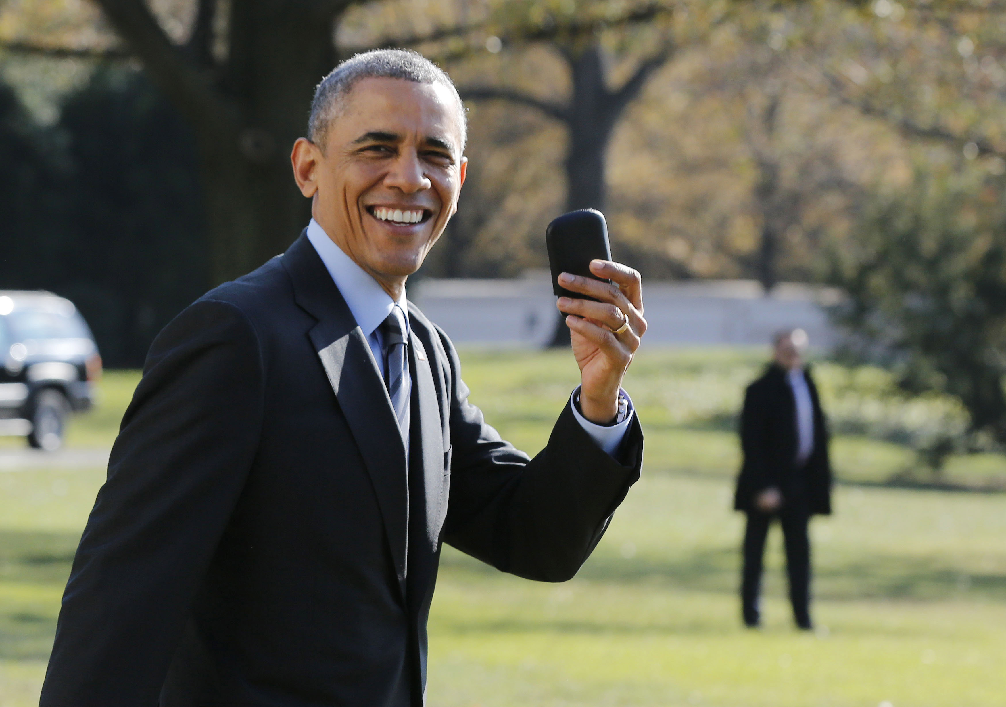 U.S. President Barack Obama holds up his BlackBerry device after he returned inside the White House to retrieve it, after boarding Marine One on the South Lawn of the White House in Washington on Nov. 21, 2014.