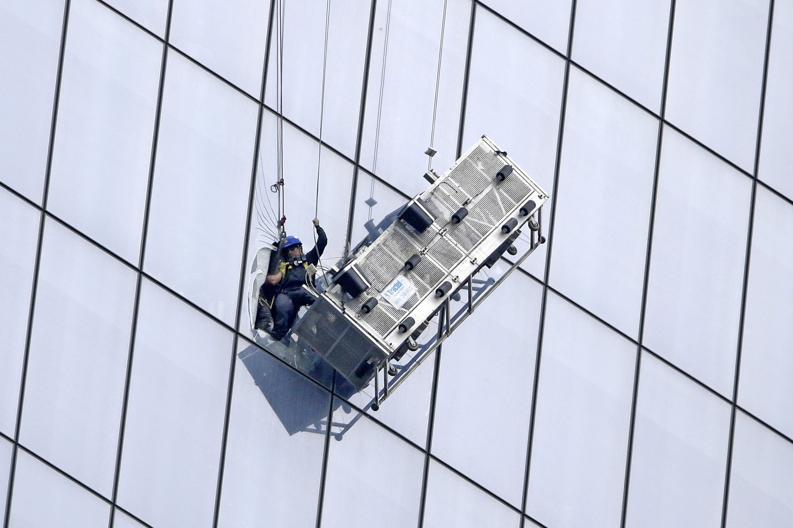 A window washer is seen being rescued by NYPD and NYFD  after his carriage came dislodged from his cables along side the One World Trade Center in New YorkCity on Nov. 12, 2014. (Jason Szenes—EPA)