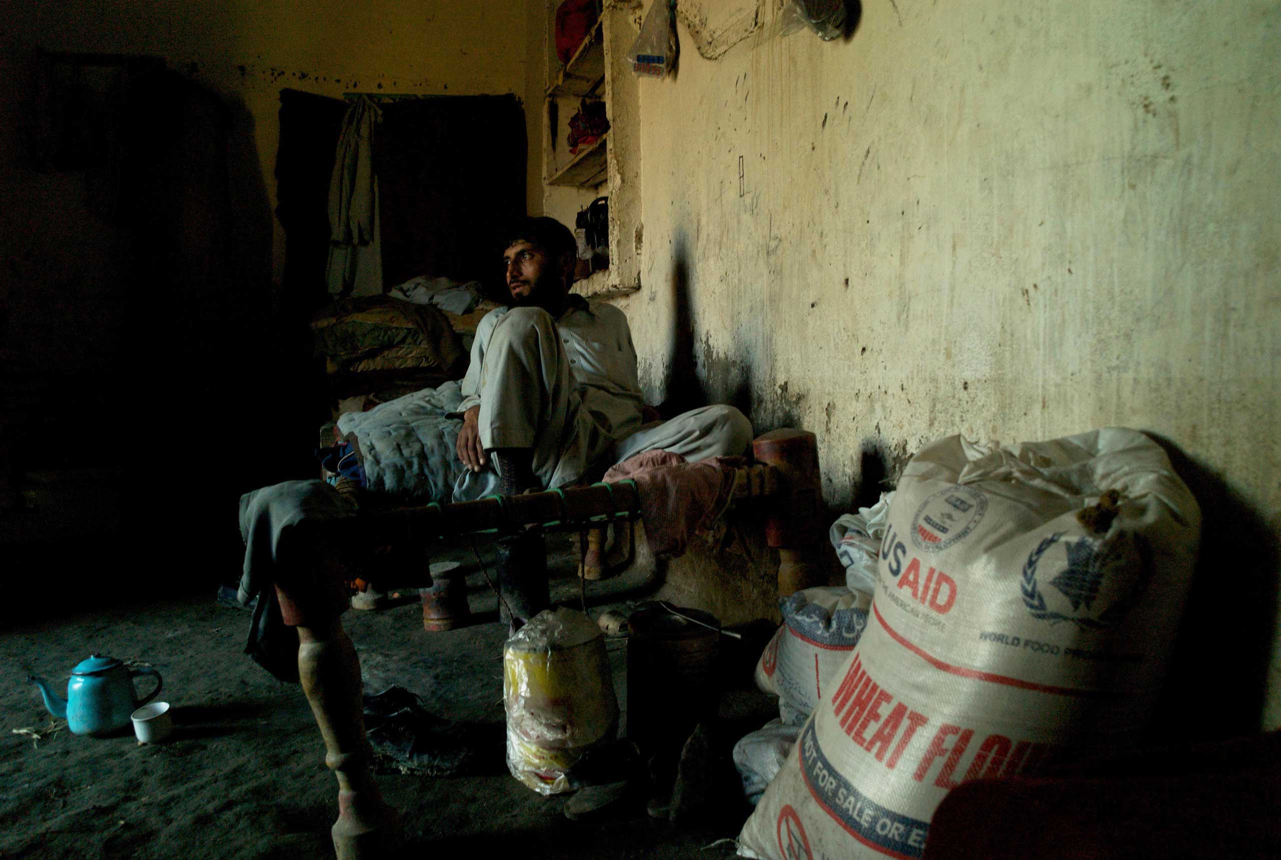 MAJOGI, PAKISTAN- JANUARY 2011 
                              Having just received a month's ration of food aid from USAID, exhausted father of five Shaukat Khan rests on a charpoi in the family's rented flood damaged house in the Charsadda having been displaced for a third time in two years.