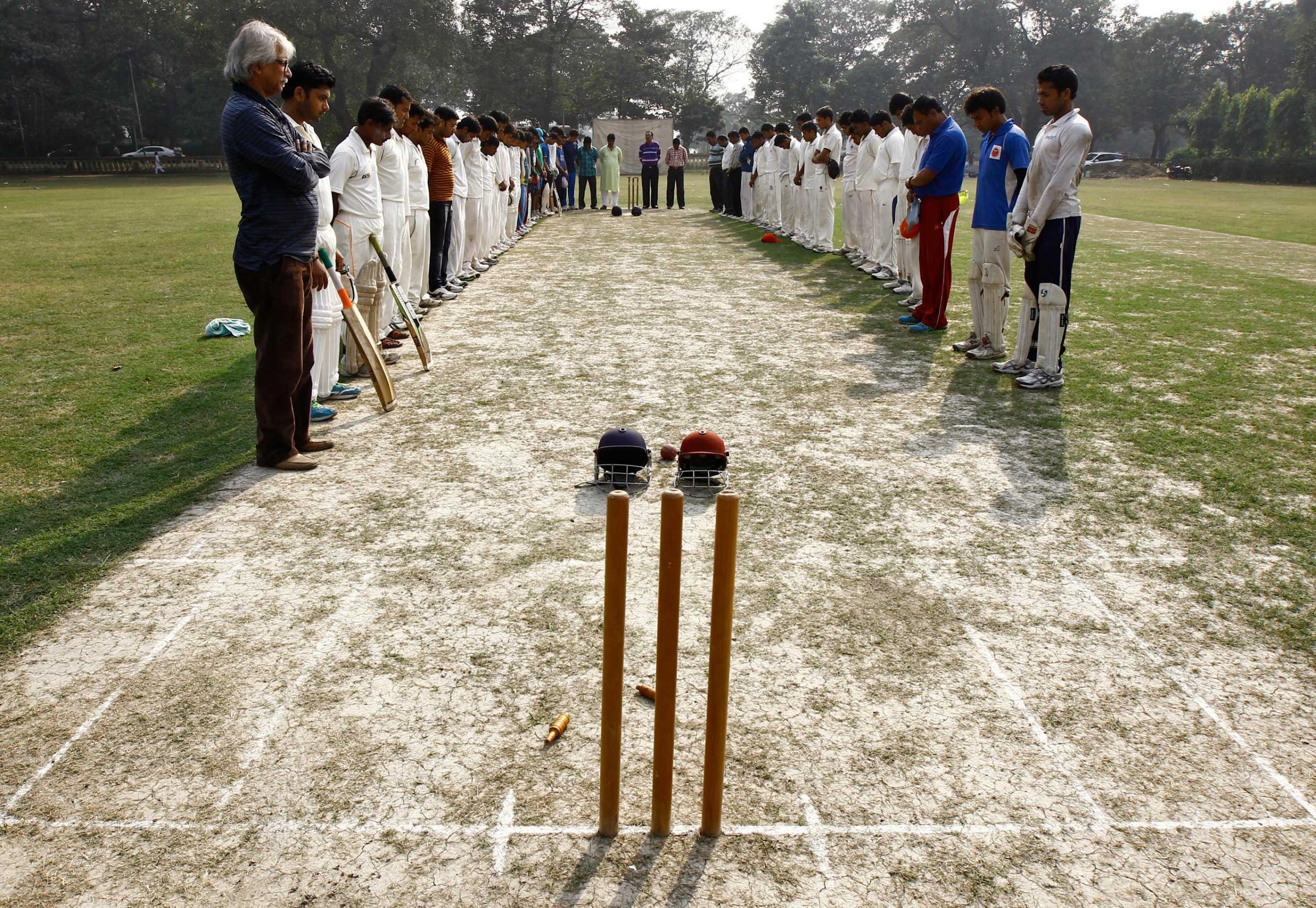 Members of two local cricket teams observe a moment of silence for Australian cricketer Hughes before their match in Kolkata