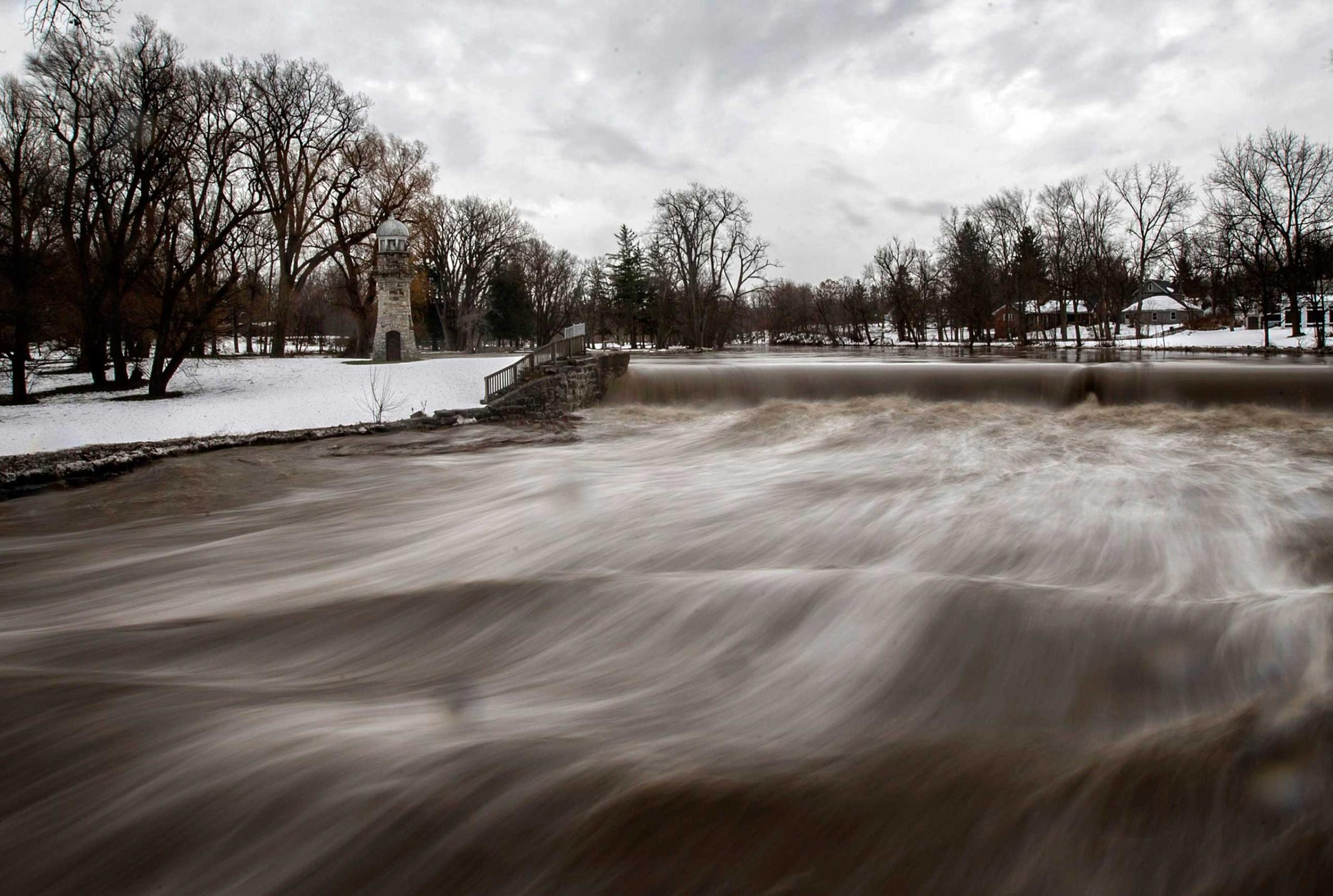 Cayuga Creek water rushes past a neighbourhood following a massive snow storm in Lancaster