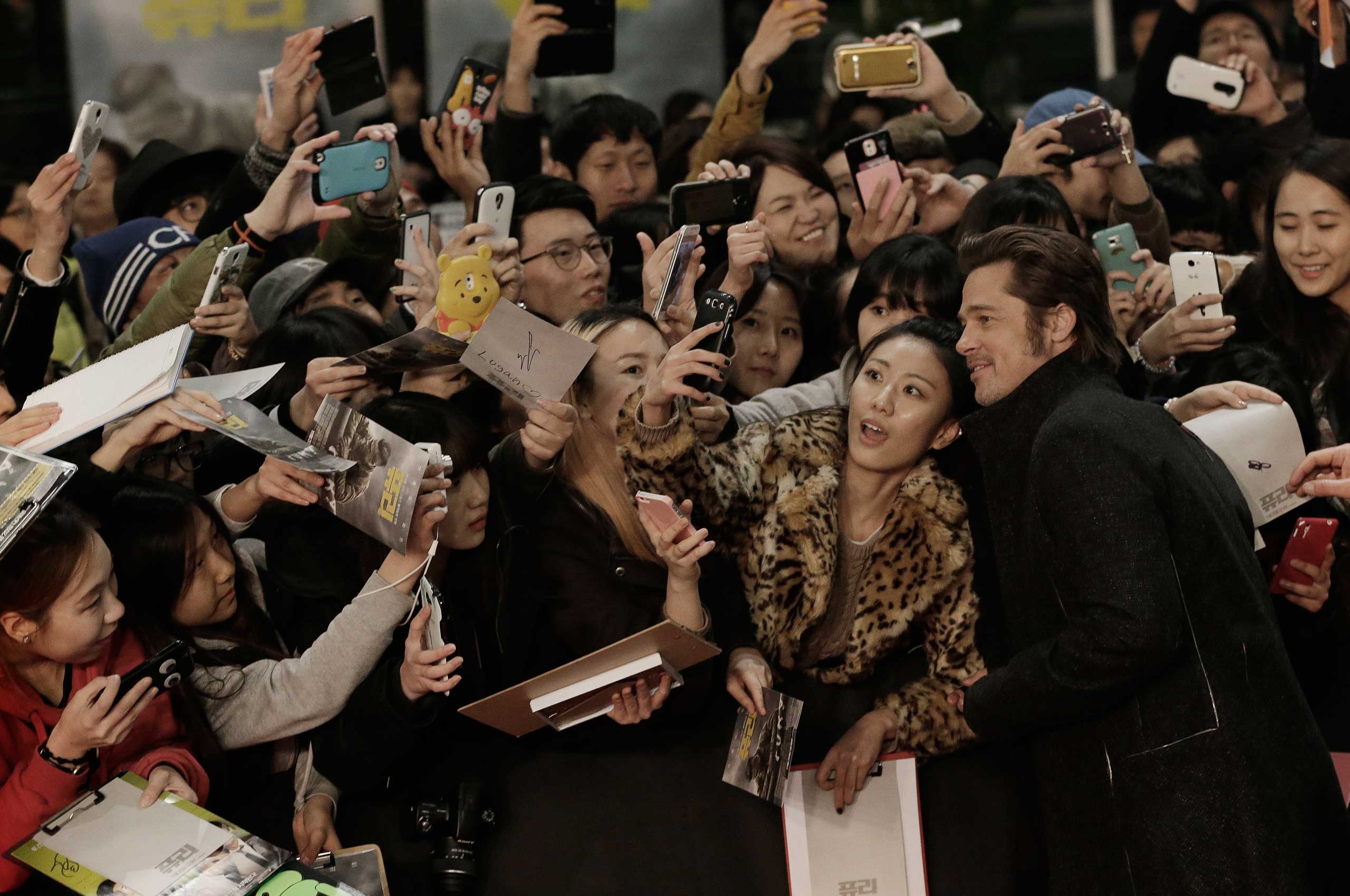 Nov. 13, 2014. Actor Brad Pitt takes pictures with fans during a promotional event for his latest film Fury in Seoul. The movie is to be released in South Korea on Nov. 20.