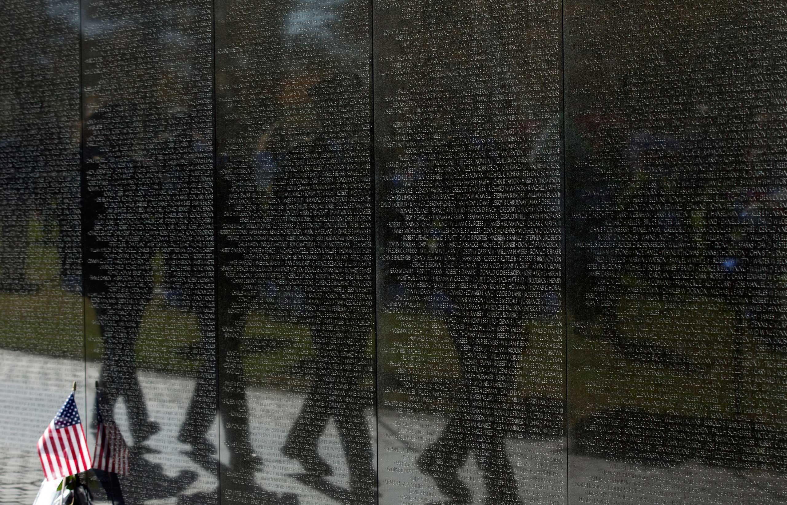 Nov. 11, 2014. The U.S. Park Police honor guards are reflected in the Vietnam Veterans Wall Memorial as they march during a ceremony to commemorate Veterans Day, in Washington, D.C.