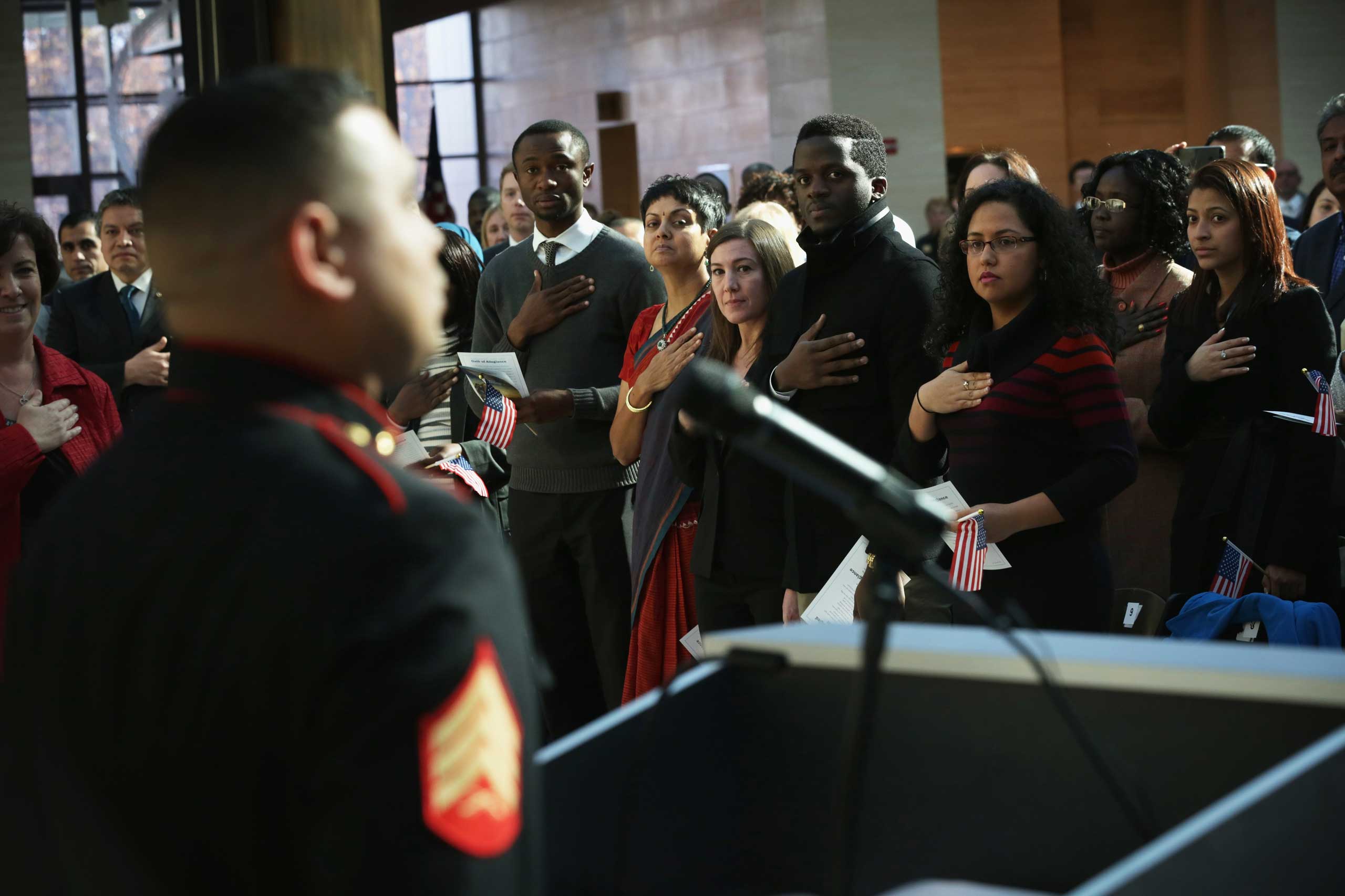 Nov. 10, 2014. New citizens recite the Pledge of Allegiance during a naturalization ceremony  at the National Museum of the Marine Corps in Triangle, Va. Service members, military veterans and civilians take part in 40 naturalization ceremonies across the country from Nov. 7 to 14 to honor Veterans Day and become U.S. citizens.