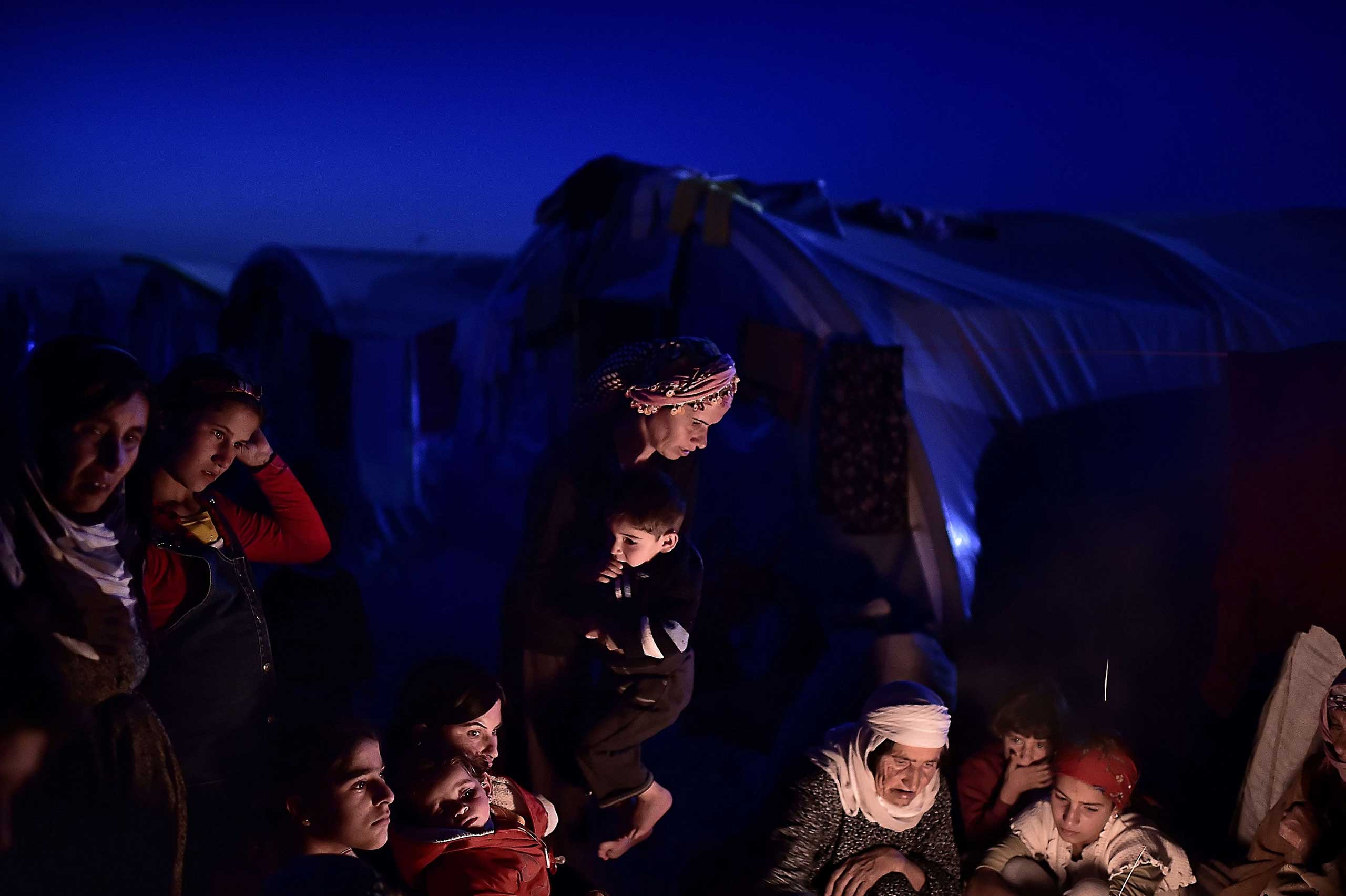 Nov. 11, 2014. Syrian Kurdish refugees sit outside tents at a refugee camp in Suruc, Sanliurfa province.