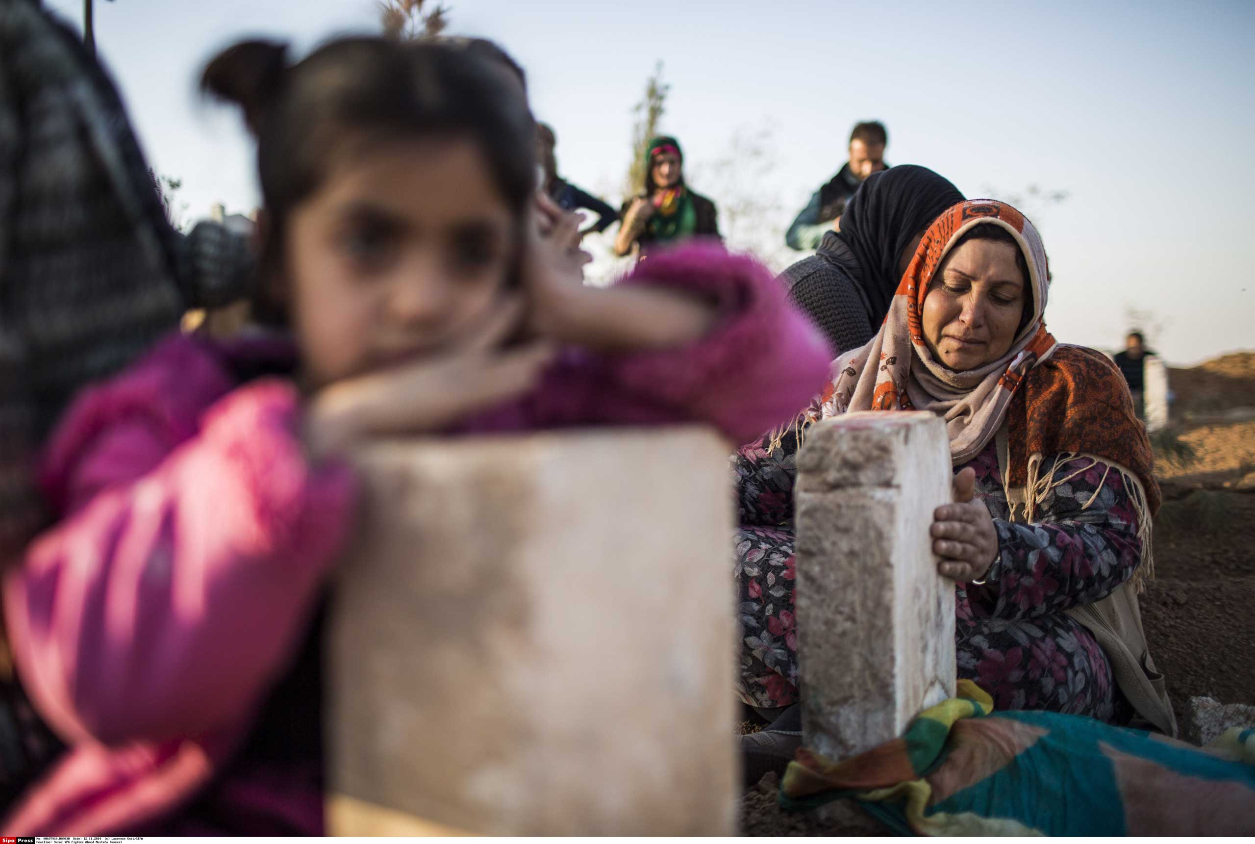 Nov. 12, 2014. Kurdish women sit by a grave of an fighter killed in clashes with the Islamic State (ISIS) forces during the funeral of People's Protection Units fighter Ahmed Mustafa, who died after being injured while fighting in the Syrian city of Kobani, in Suruc, on the Turkey-Syria border.