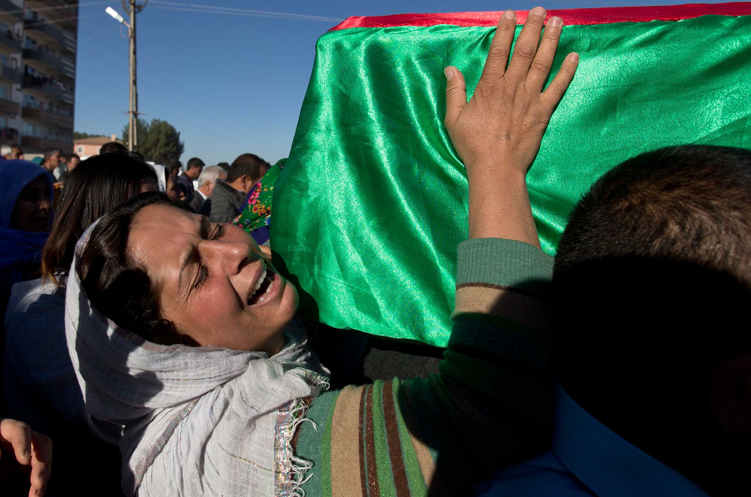 Nov. 7, 2014. A mourner cries holding onto the coffin of 19 year-old Syrian Kurdish female fighter Perwin Mustafa Dihap who died in Suruc, on the Turkey-Syria border, after being wounded during fighting against the Islamic State (ISIS) forces in her home town of Kobani.