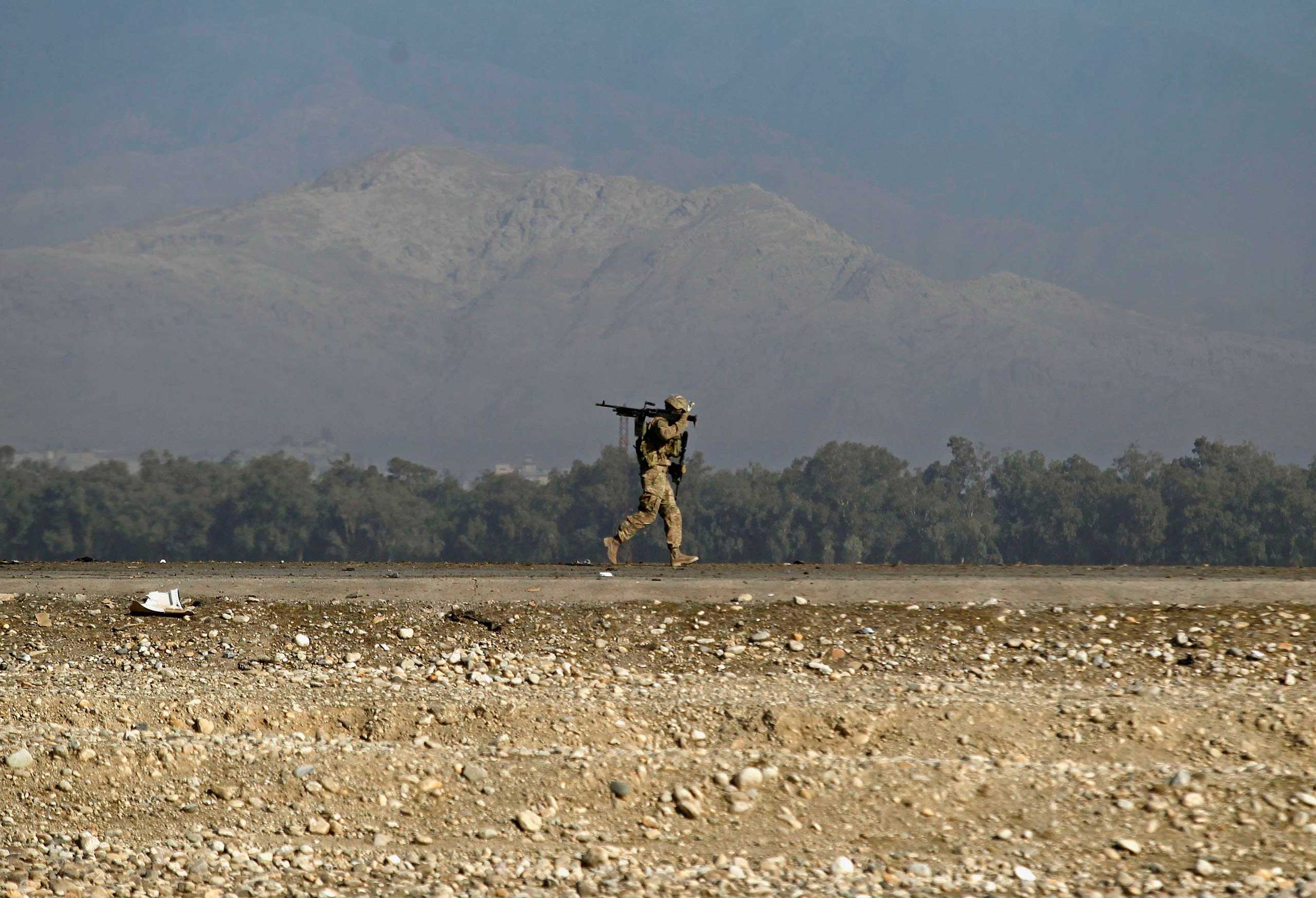 Nov. 13, 2014. A U.S. soldier walks at the site of a suicide attack on the outskirts of Jalalabad in eastern Afghanistan. The suicide bomber rammed his explosive-laden vehicle into U.S. forces traveling in a NATO convoy on Thursday. The attack caused no fatalities to foreign forces or civilians, but damaged an armored vehicle, the provincial spokesman Ahmadzia Abdulzai said.