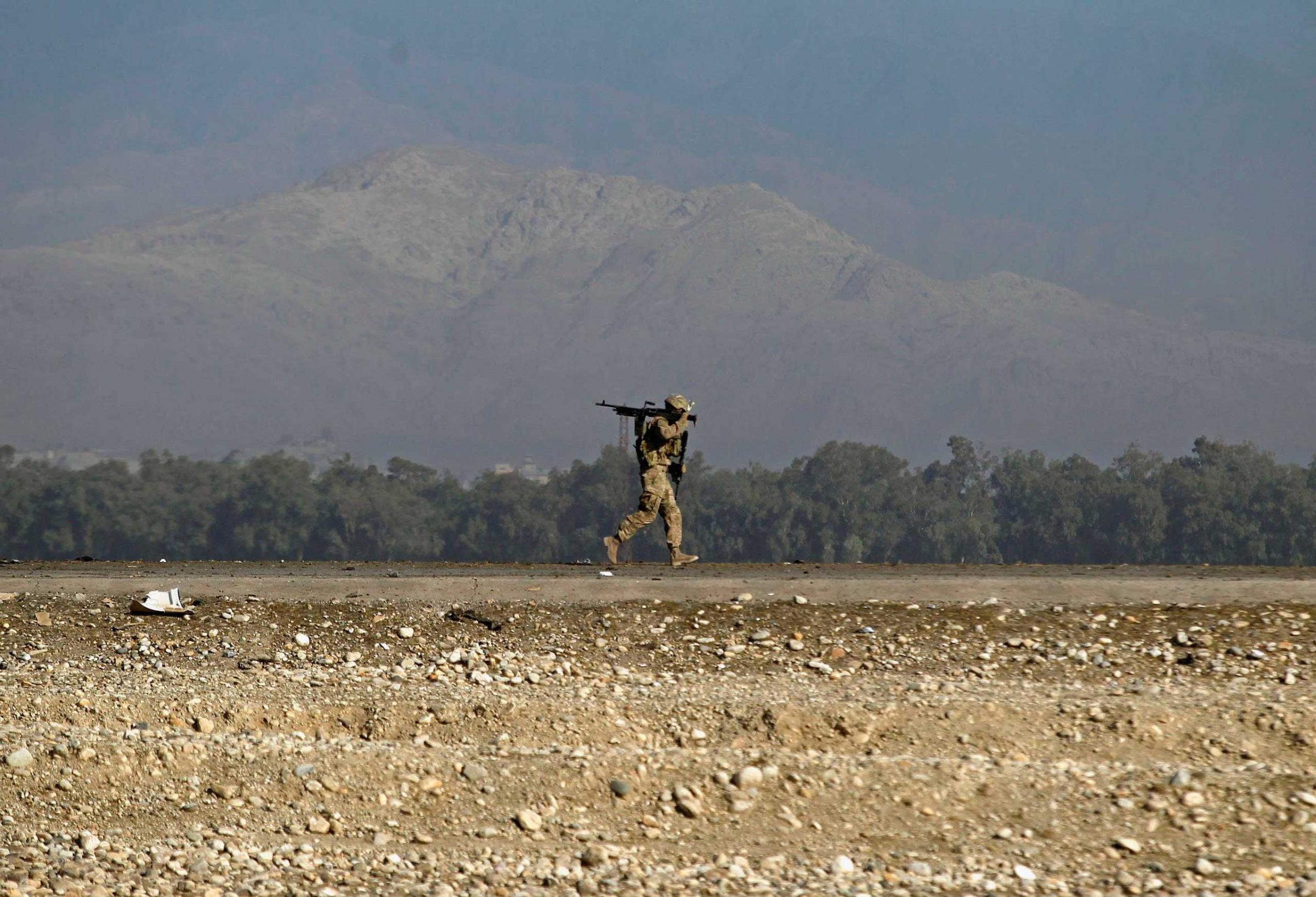 A U.S. soldier walks at the site of a suicide attack on the outskirts of Jalalabad
