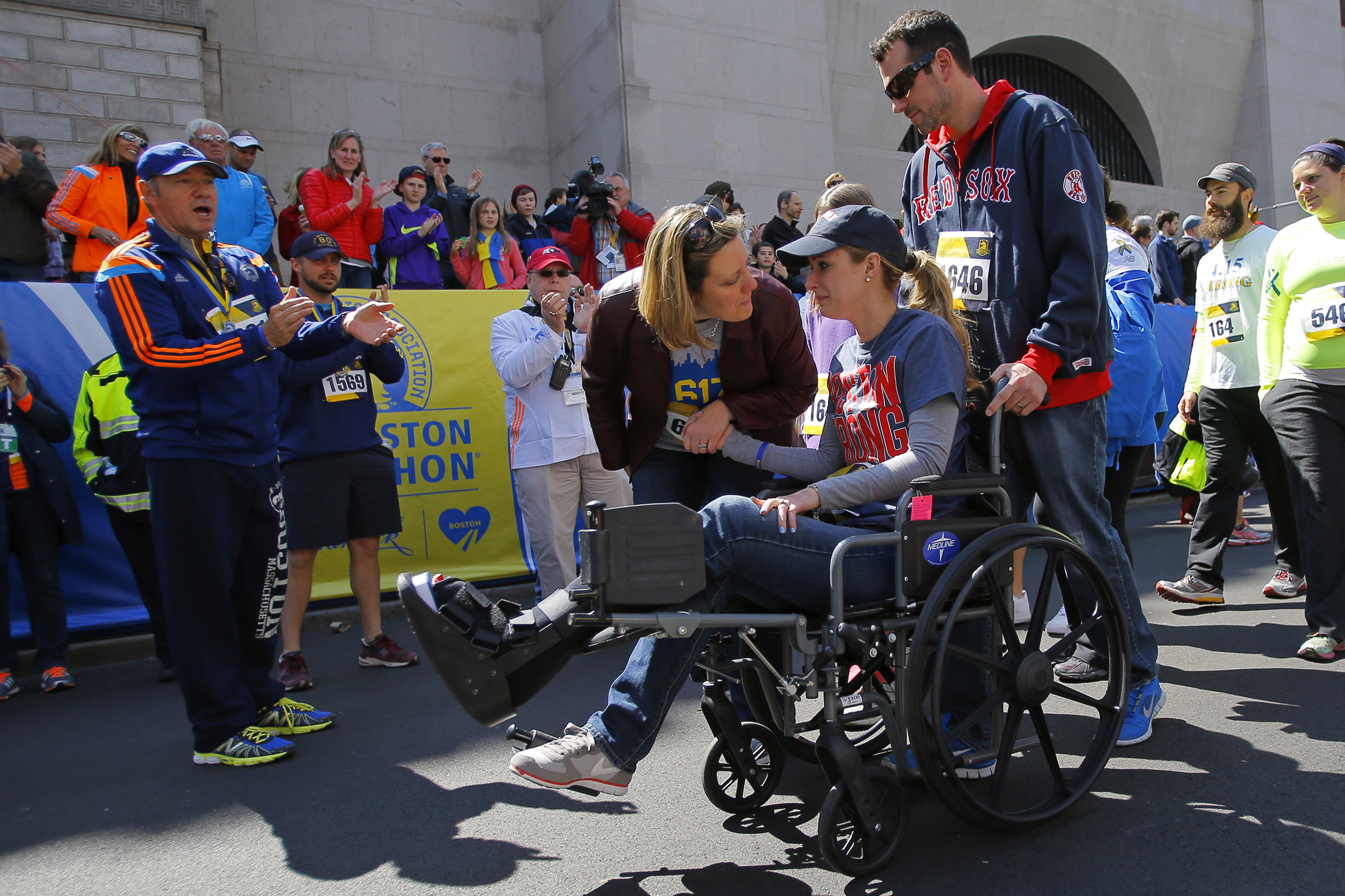 Actor Kevin Spacey (L) cheers on as 2013 Boston Marathon bombing survivor Rebekah Gregory DiMartino (2nd R) crosses the marathon finish line during a Tribute Run for survivors and first responders in Boston on April 19, 2014. (Brian Snyder—Reuters)