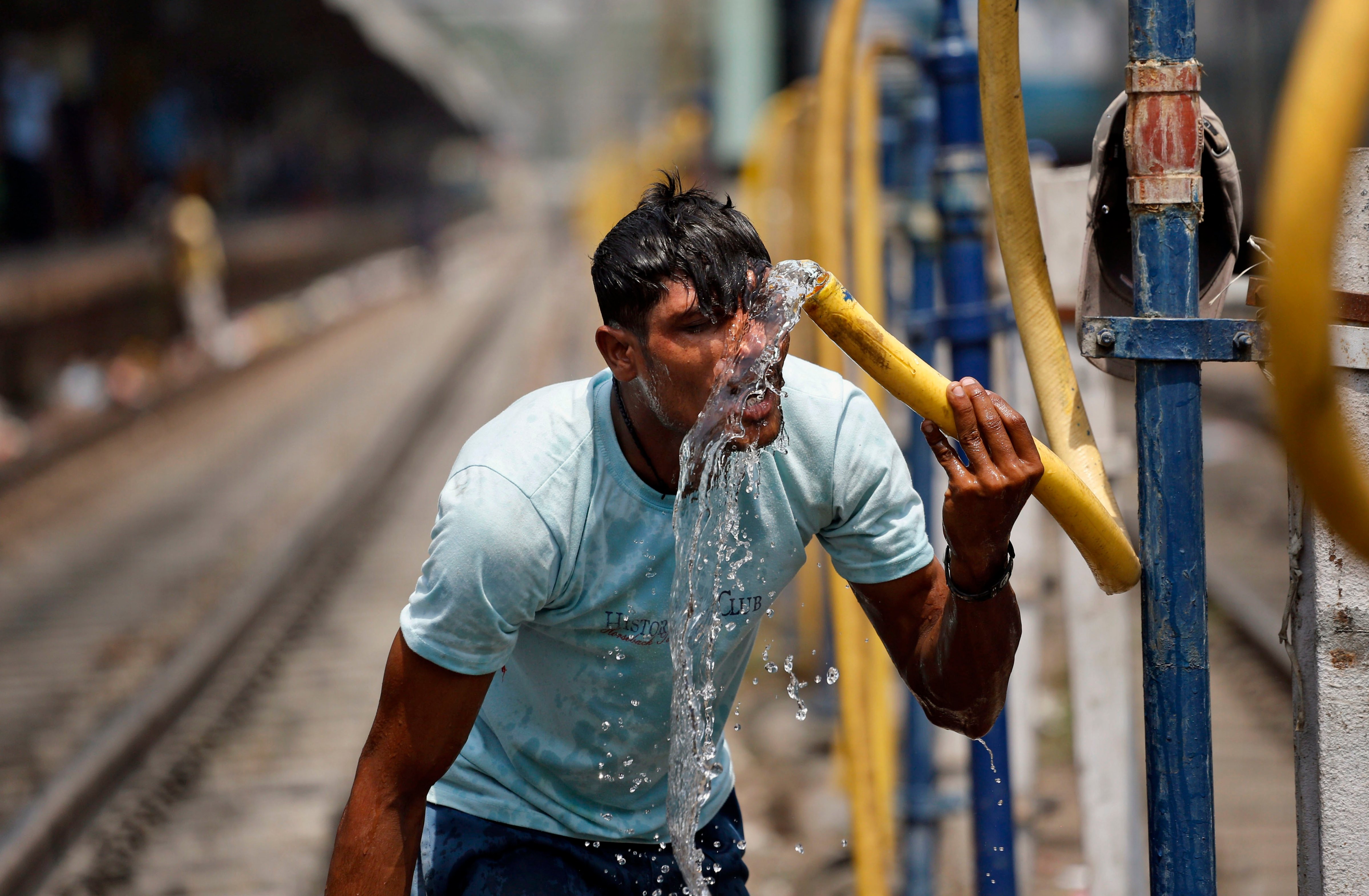 An Indian commuter splashes water from a pipe onto his face to get respite from the heat at the railway station in Allahabad, India, on June 7, 2014 file photo (Rajesh Kumar—AP)