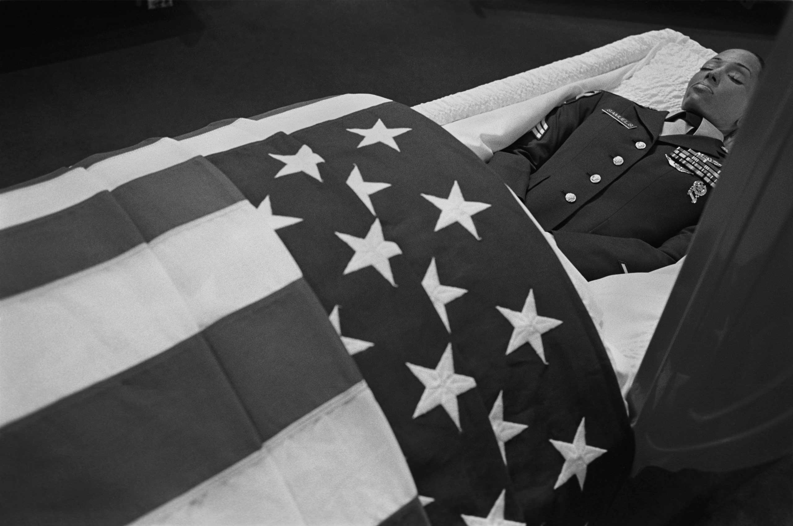 Sergeant Princess Samuels.
                              Eugene Richards, Aug. 31, 2007. Landover, Md.
                              
                               The flag-draped coffin holding Sergeant Princess Samuels was wheeled slowly down the aisle into the chapel. Then, though I’d been told that the coffin would remain closed, the lid was raised. In the sudden glare of the overhead light, what I saw at first seemed an image out of a fairy tale: a beautiful young woman asleep in a kind of jewelry box. When I moved closer, I could see the unnatural thinness, brittleness of her eyelids, her swollen, impacted lips and the scars that ran down her face beneath her jaw.